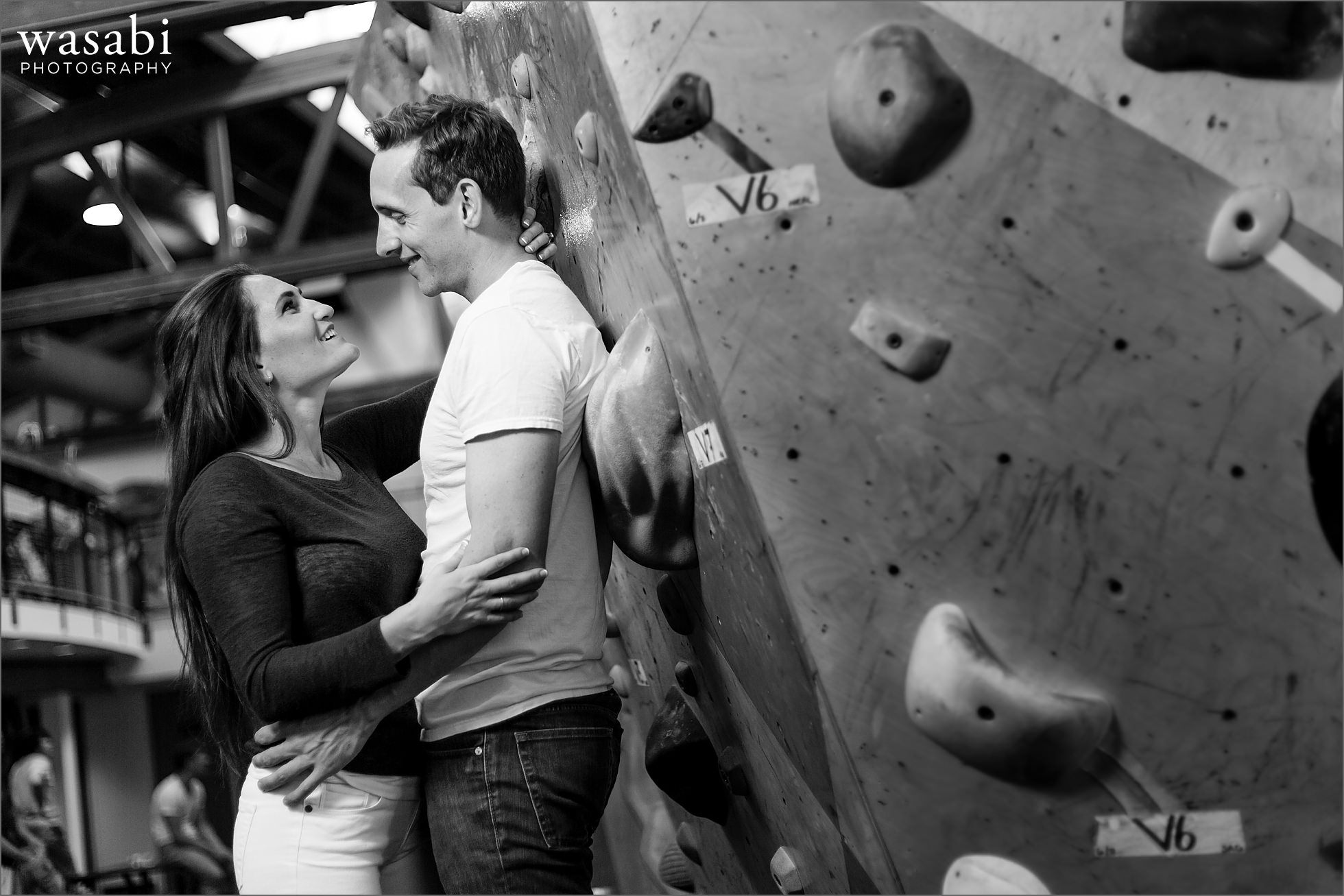 couple laughs during rock climbing engagement photos at Brooklyn Boulders in Chicagos West Loop neighborhood