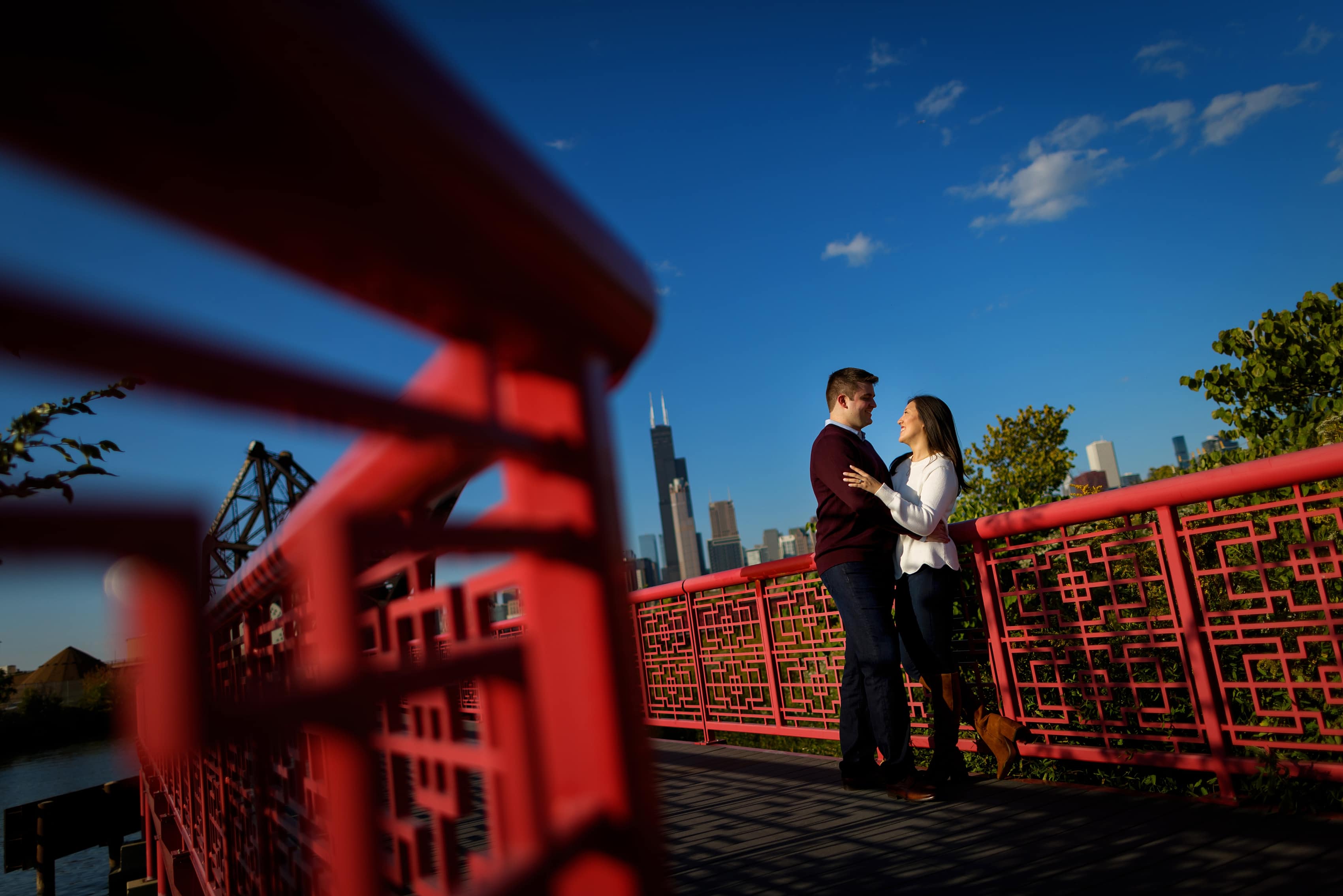 Couple poses for engagement photos at Ping Tom Memorial Park in Chicago's Chinatown neighborhood with the skyline in the background