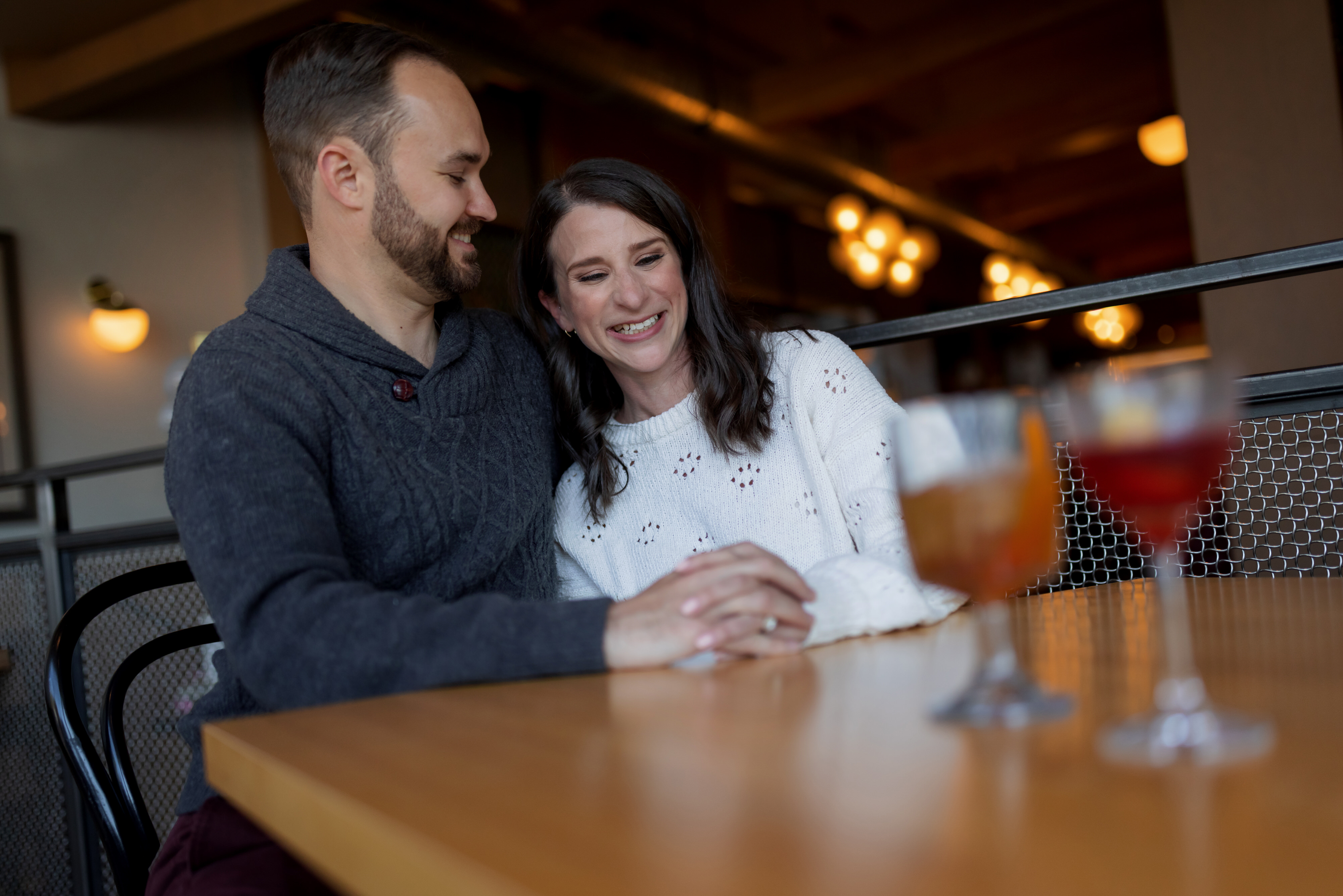 couple poses for engagement photos with drinks at Funkenhausen in Chicago