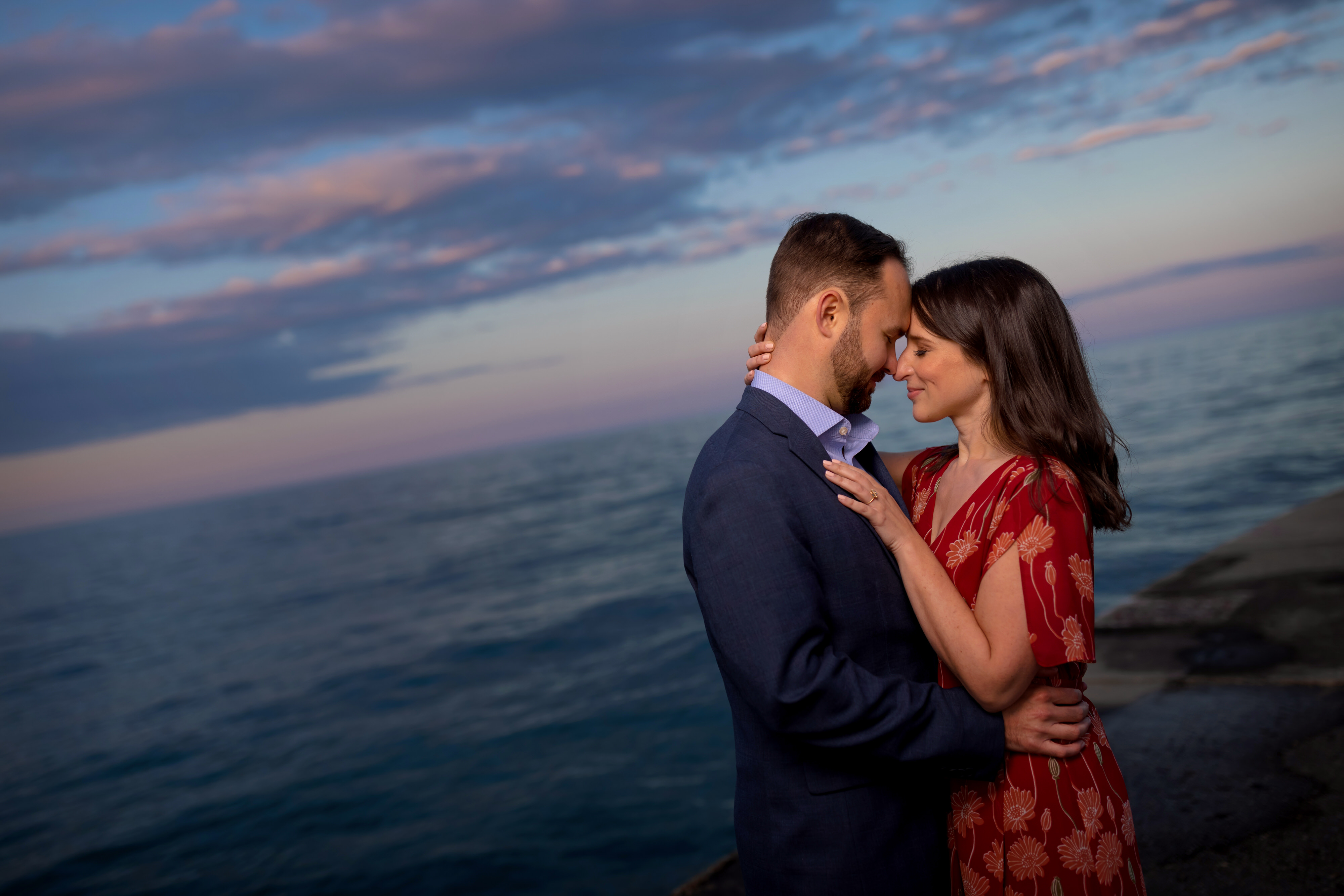 Couple poses for a portrait on the pier at North Avenue Beach in Chicago's Old Town neighborhood during an engagement session