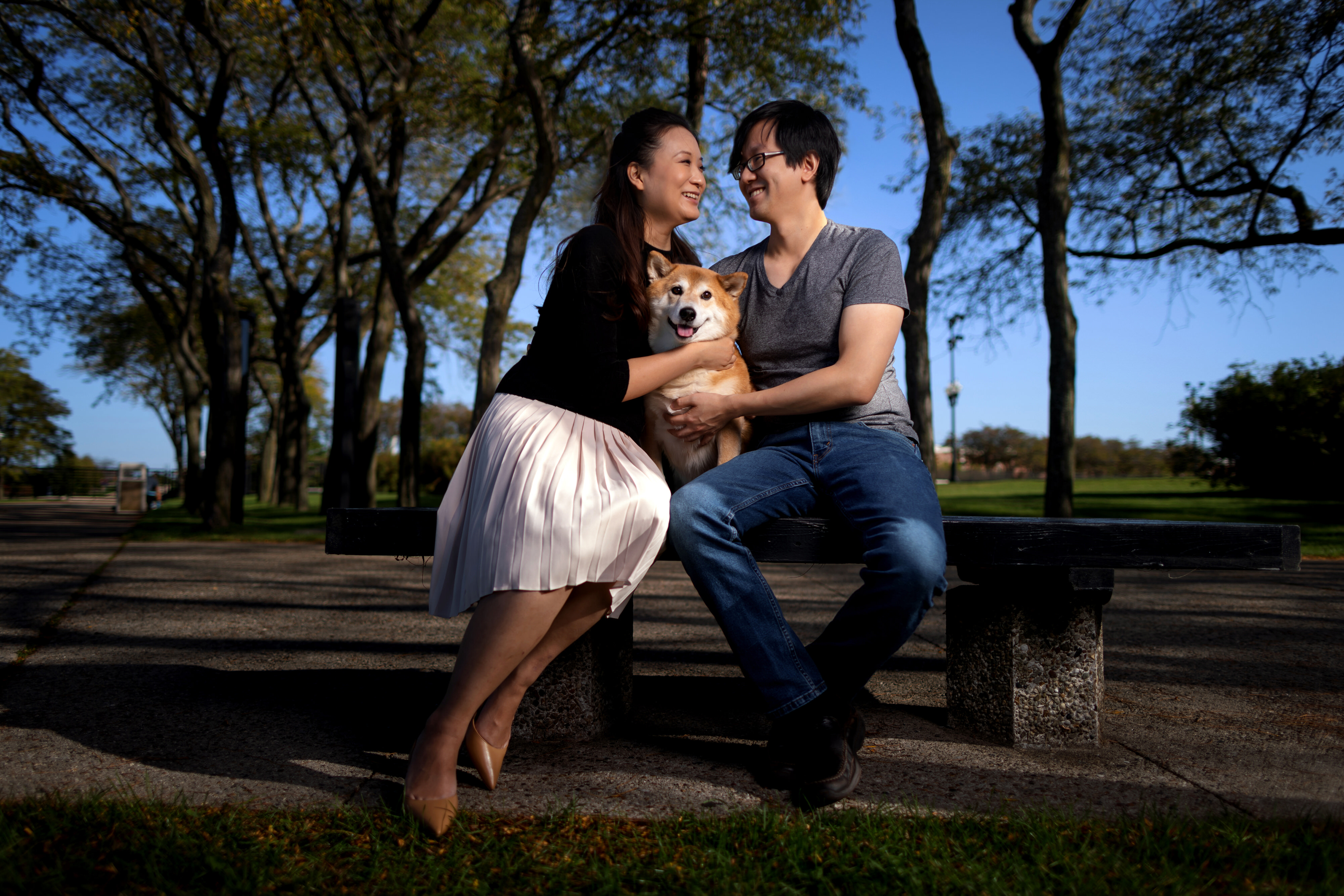 couple poses for engagement photos with their dog at milton lee olive park in chicago
