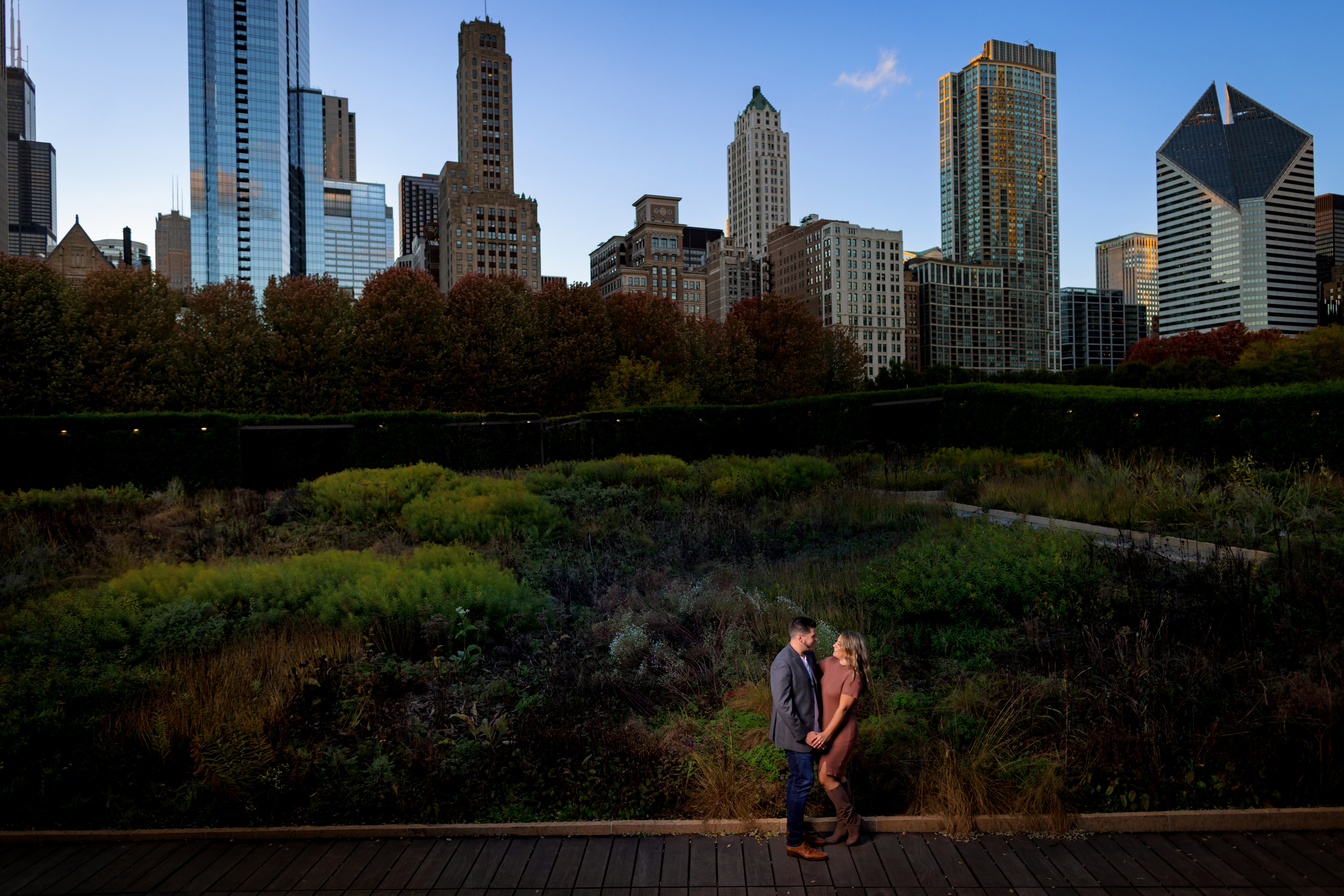 couple poses for engagement photos in Lurie Garden at Millennium Park in downtown Chicago