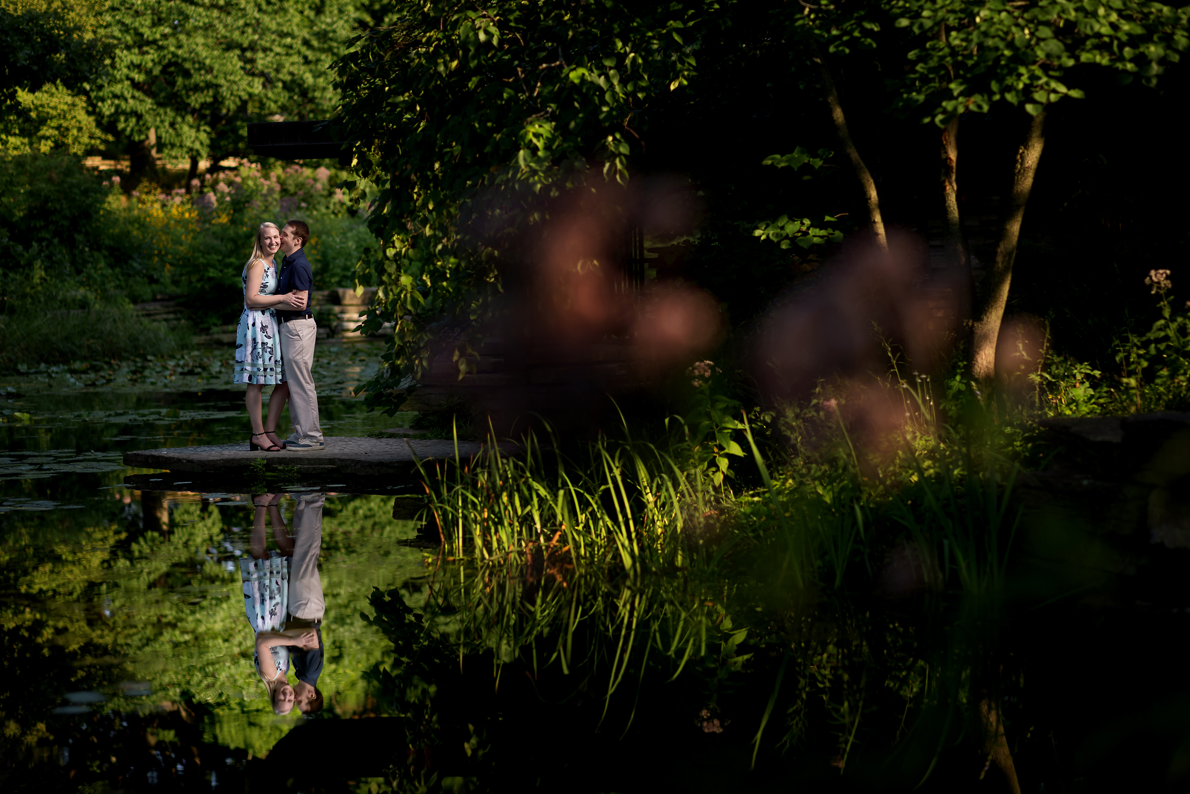 couple poses for engagement photos at alfred caldwell lily pool in Chicago's Lincoln Park