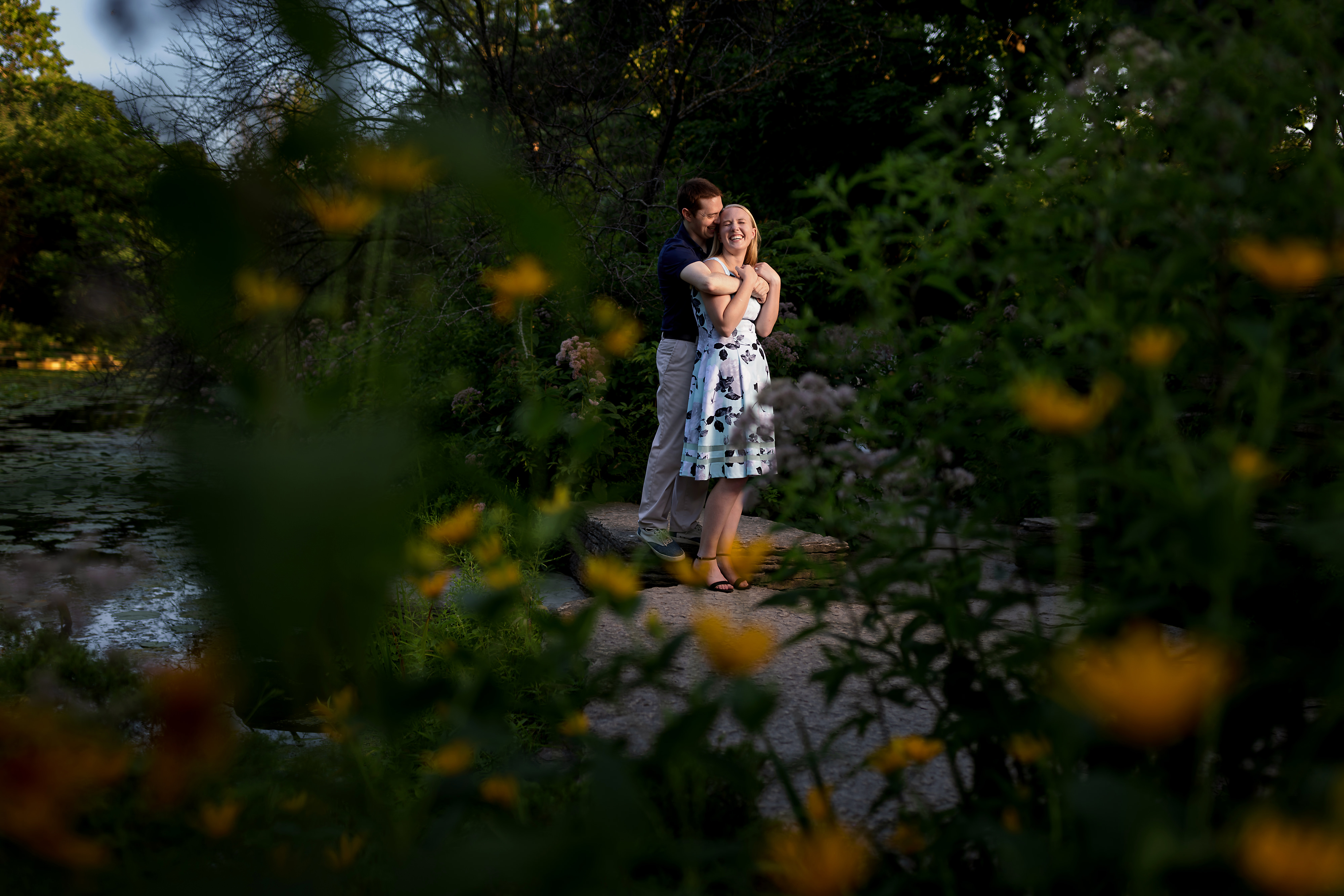 couple poses for engagement photos at alfred caldwell lily pool in Chicago's Lincoln Park