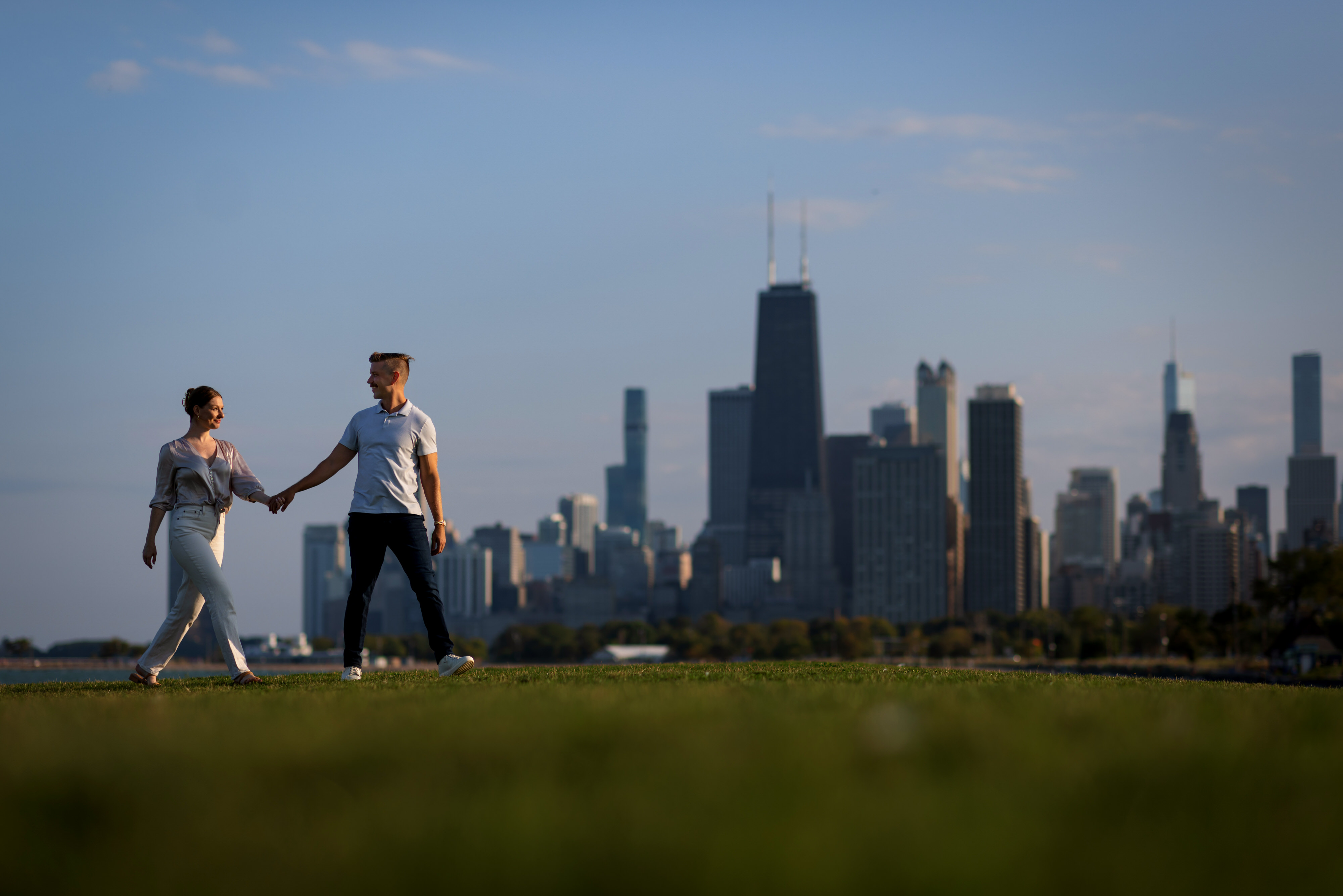 Couple walks together during engagement session at Fullerton Ave. Beach in Chicago's Lincoln Park neighborhood 