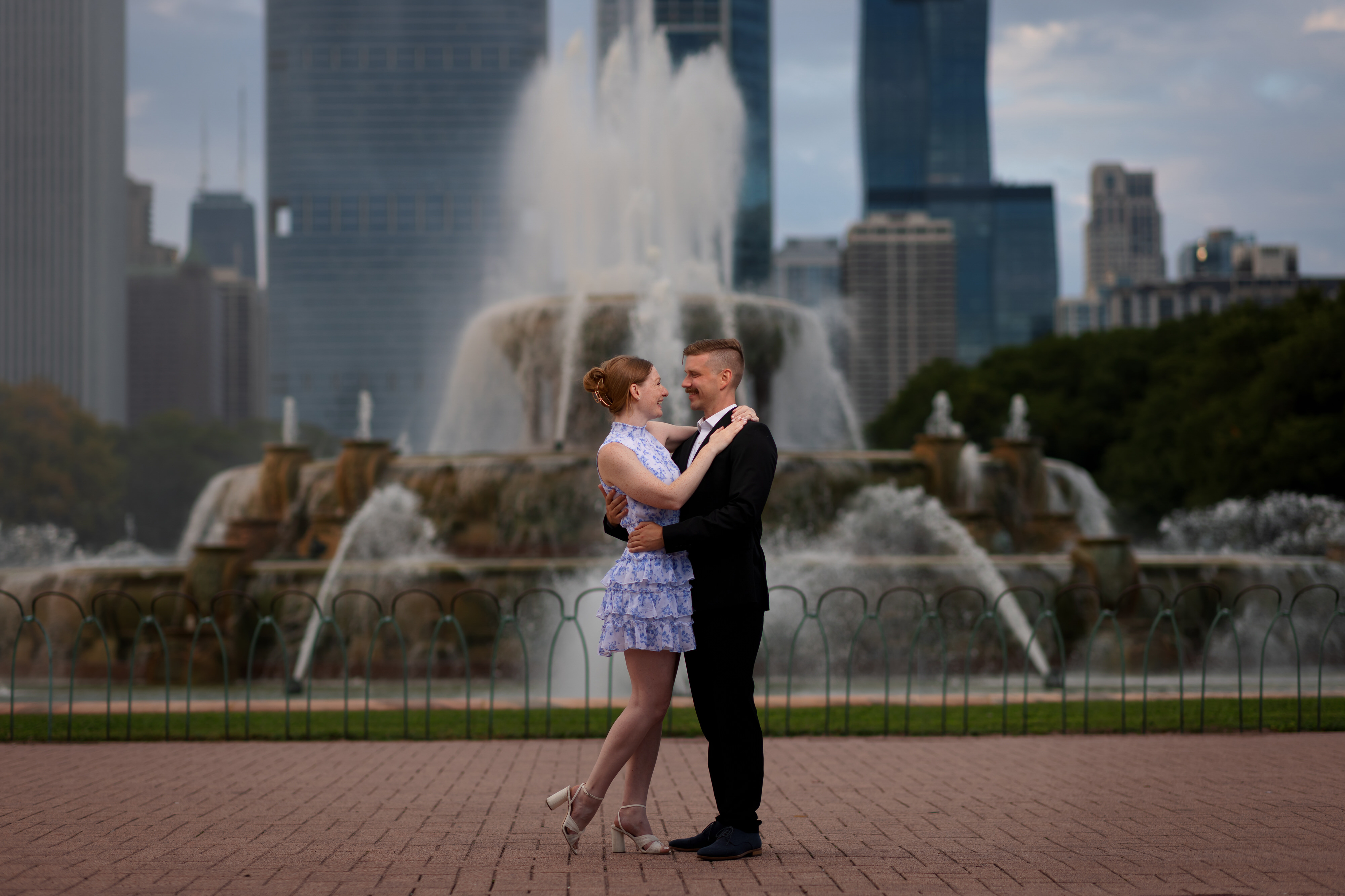Couple poses for photos together in front of Buckingham Fountain during downtown engagement session