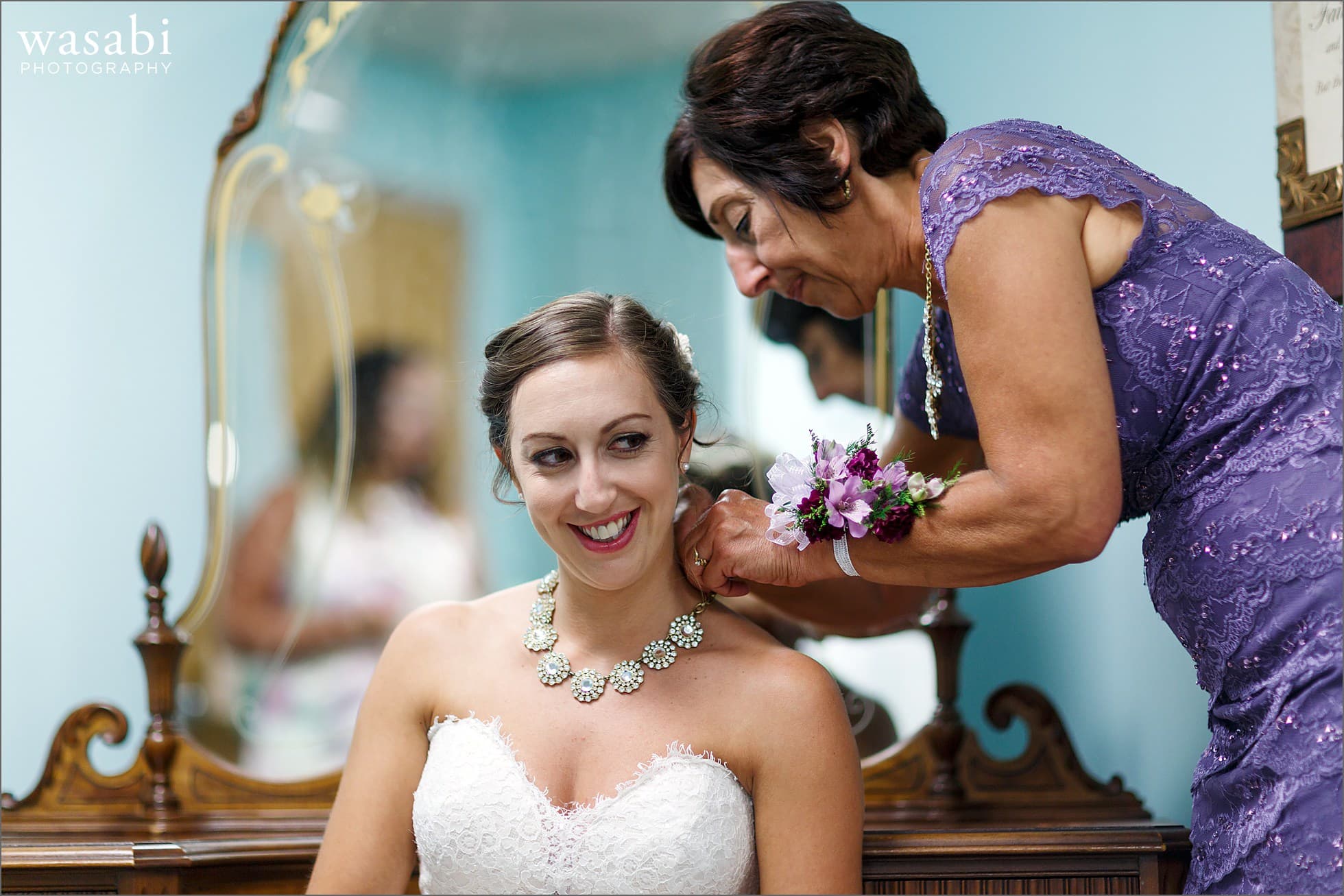 mom bride putting necklace on