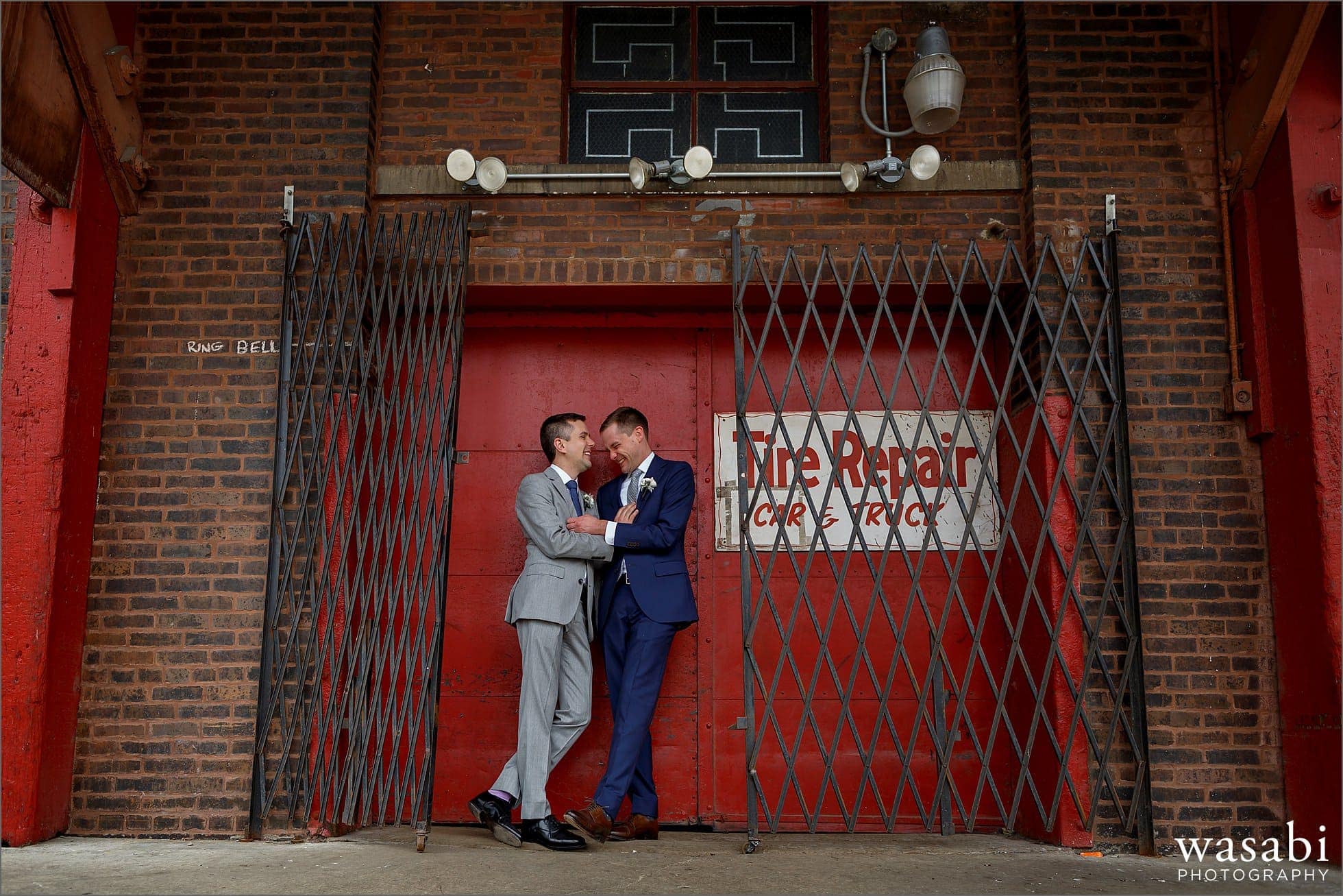 two grooms laugh during a portrait session in Chicagos West Loop neighborhood on their wedding day