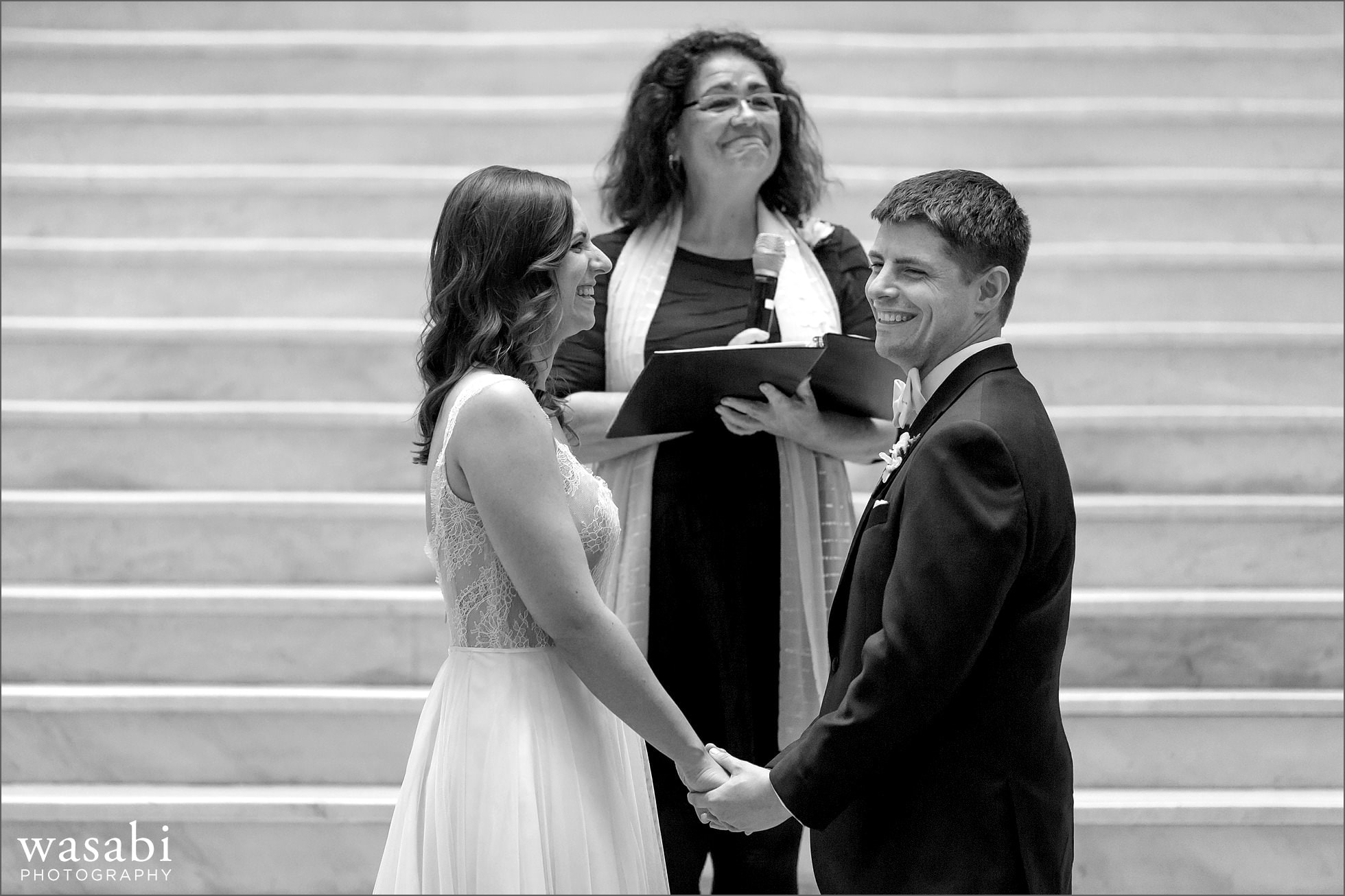 bride and groom laugh during their wedding ceremony at The Rookery Building in Chicago