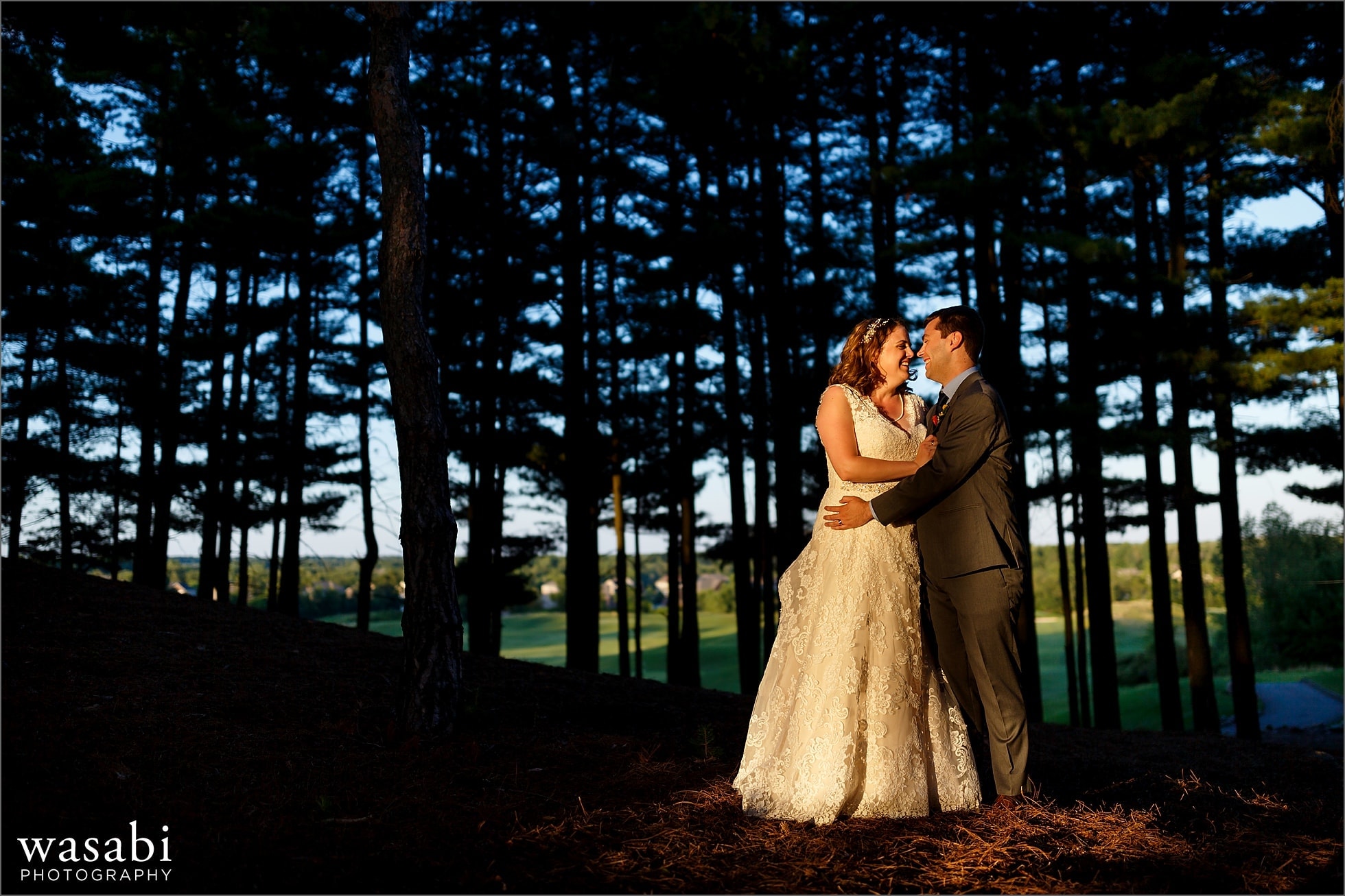 bride and groom laugh during Oakhurst Country Club wedding photos portrait session in pine trees 