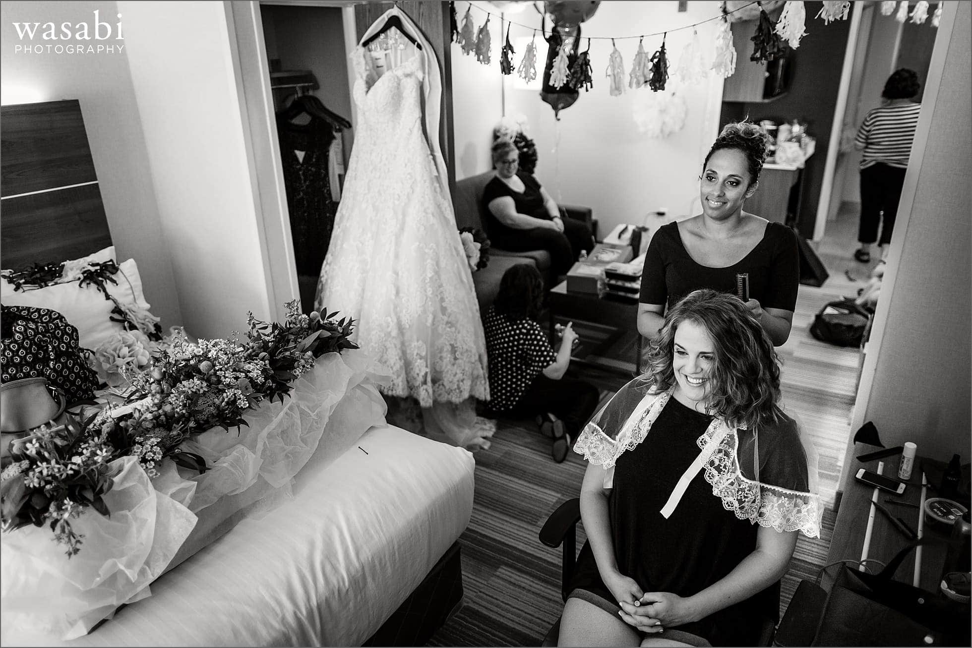 bride smiles while having her hair done before her wedding at Oakhurst Country Club in Clarkston, Michigan