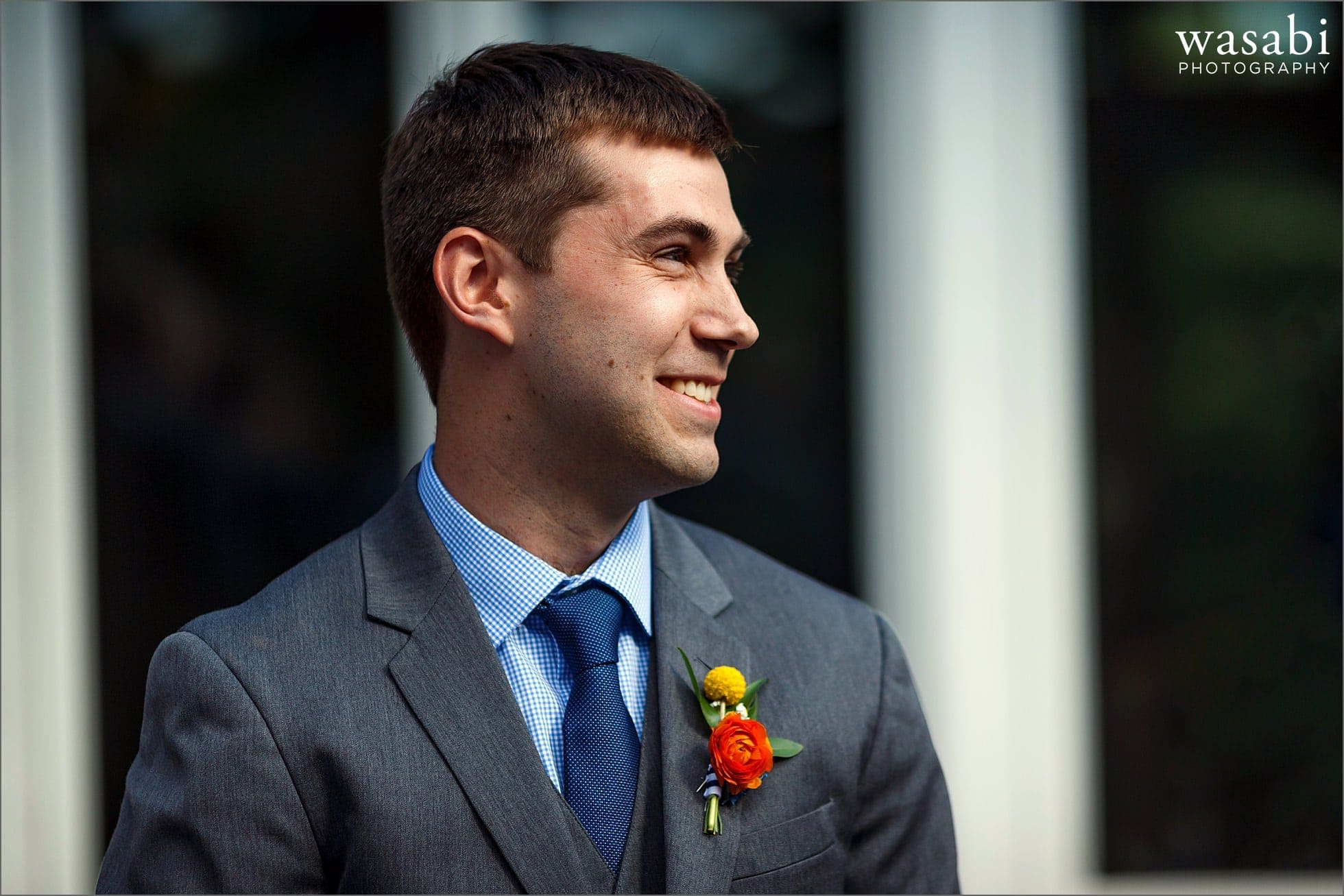 groom smiles at bride walking down the aisle during wedding ceremony at Oakhurst Country Club in Clarkston, Michigan