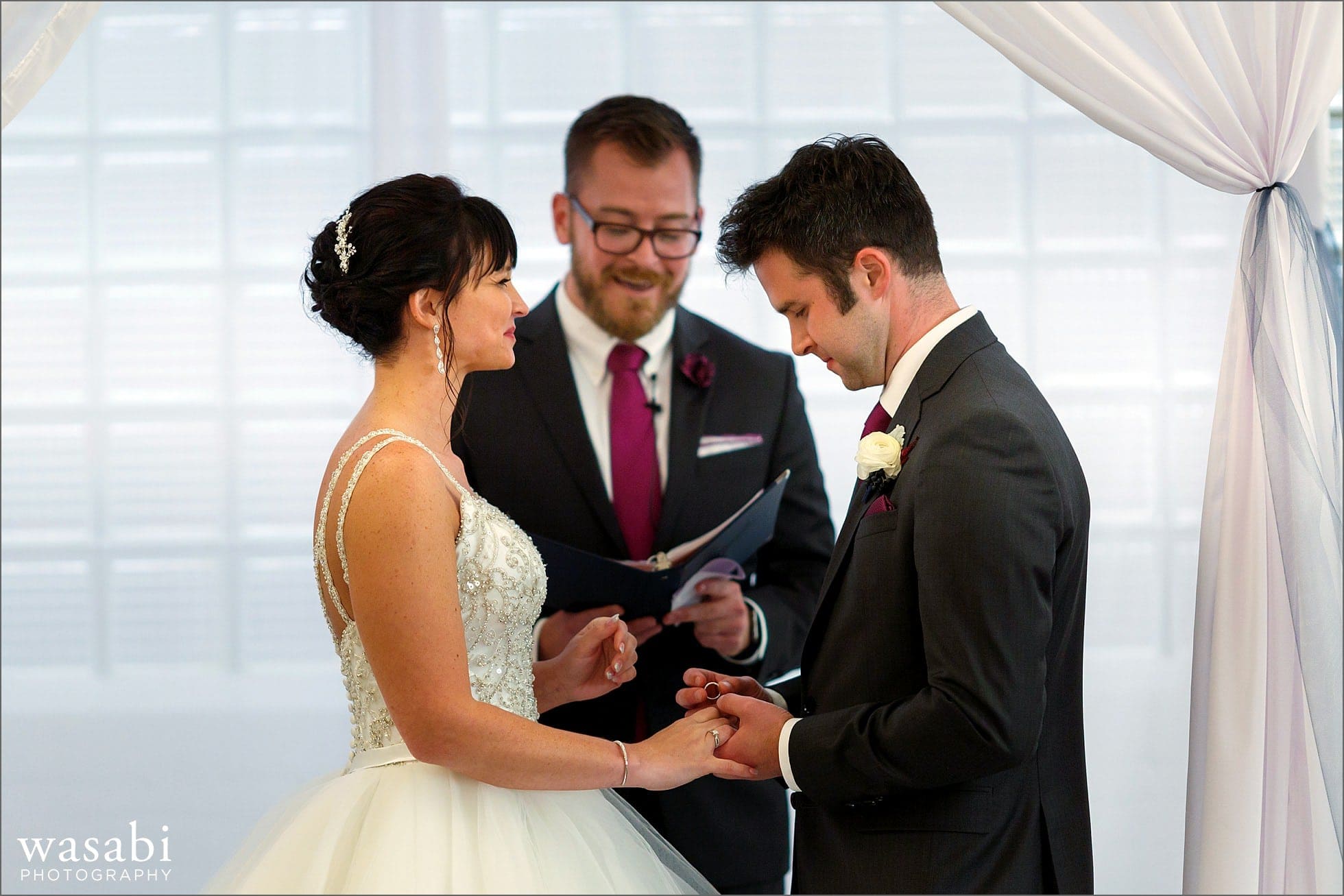 bride and groom exchange rings during wedding ceremony at Room 1520 in Chicago