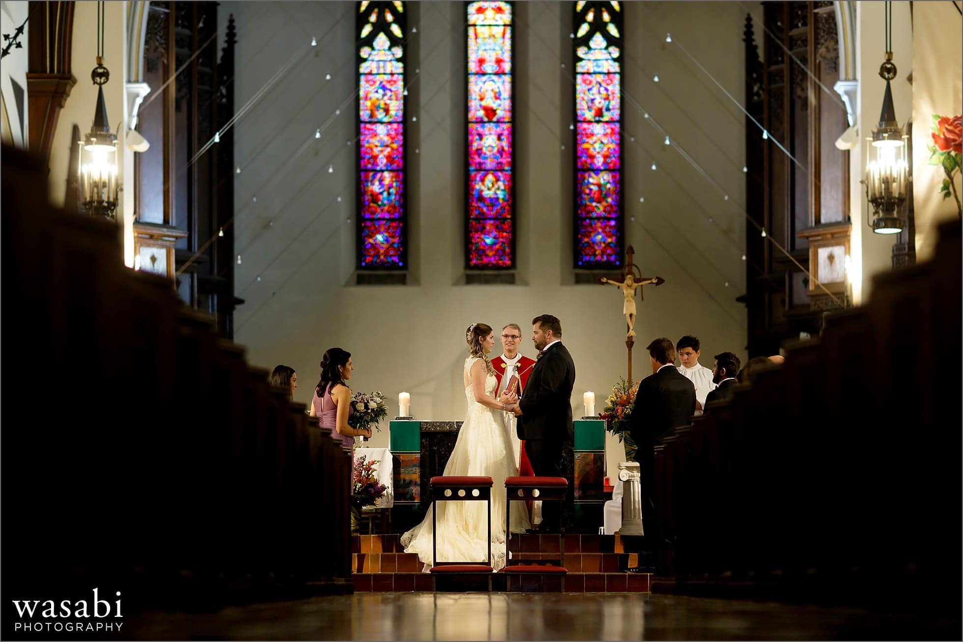 bride and groom exchange rings during wedding ceremony at St Luke Roman Catholic Church in River Forest