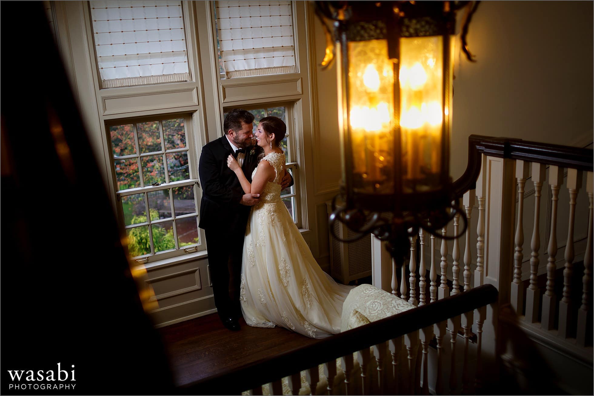 bride and groom pose for a wedding portrait on the staircase at Cheney Mansion in Oak Park