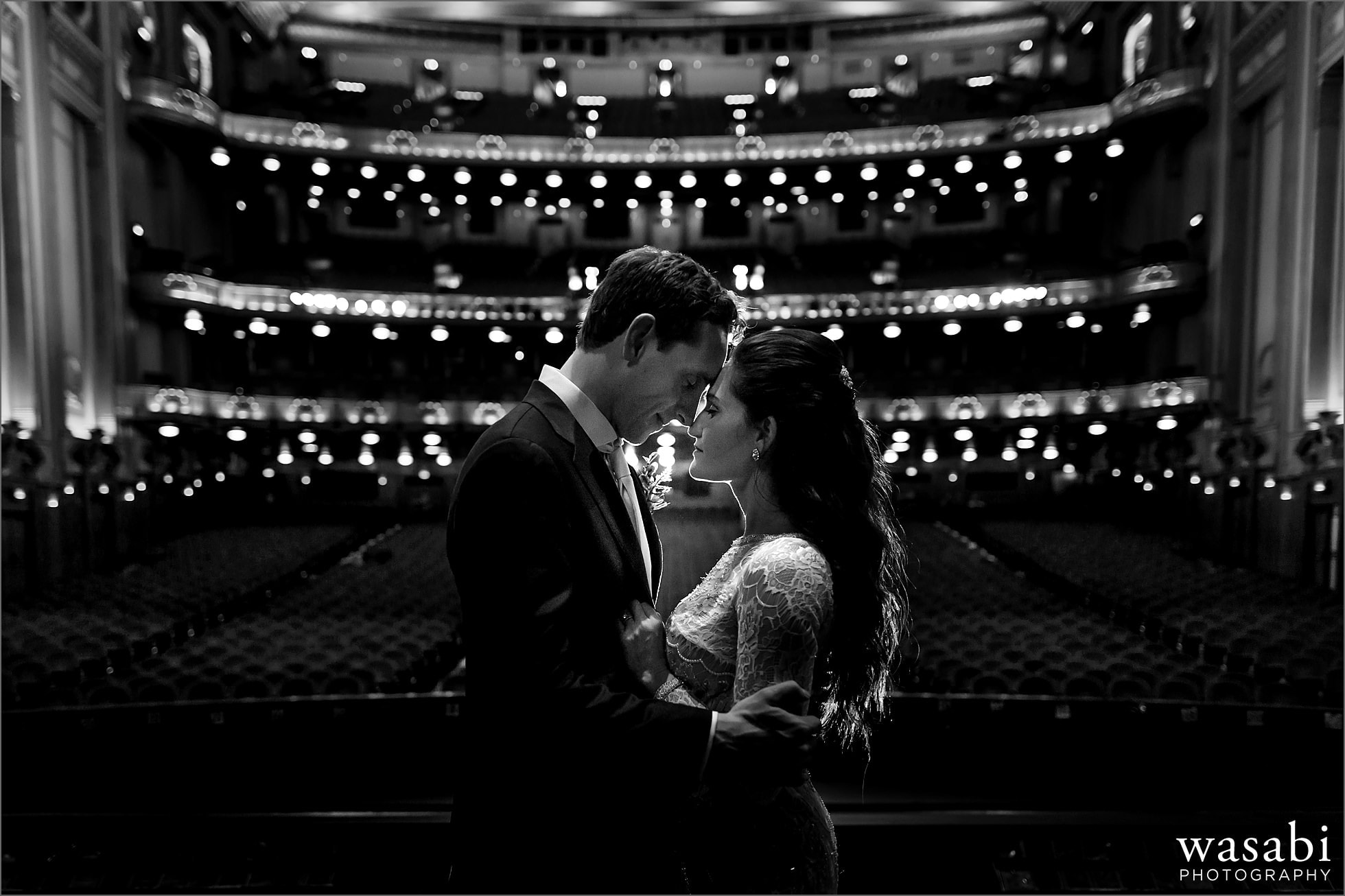 bride and groom pose for portrait on stage at Lyric Opera House Chicago wedding