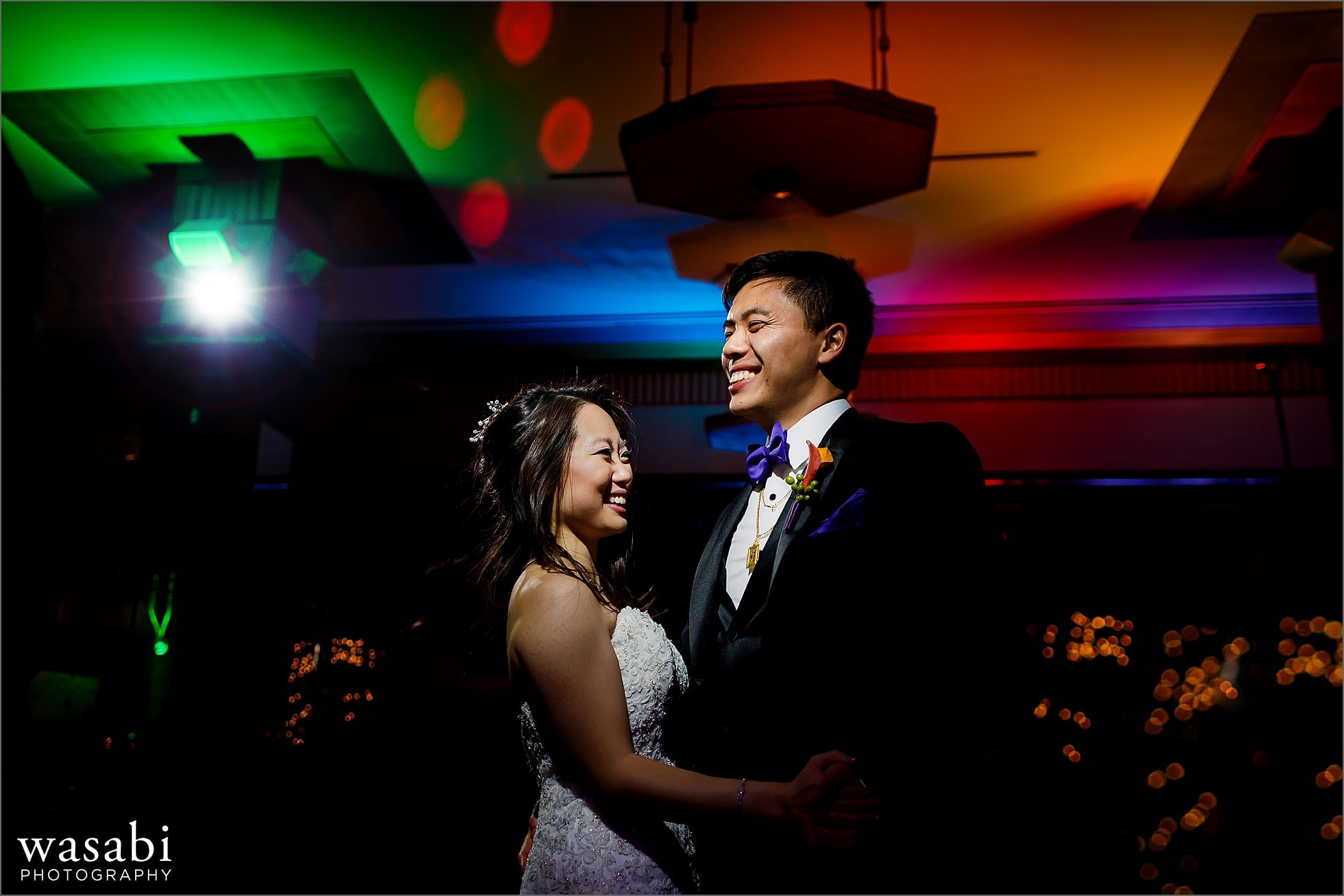 bride and groom on the dance floor with awesome color up lighting during Montgomery Club wedding reception in Chicago