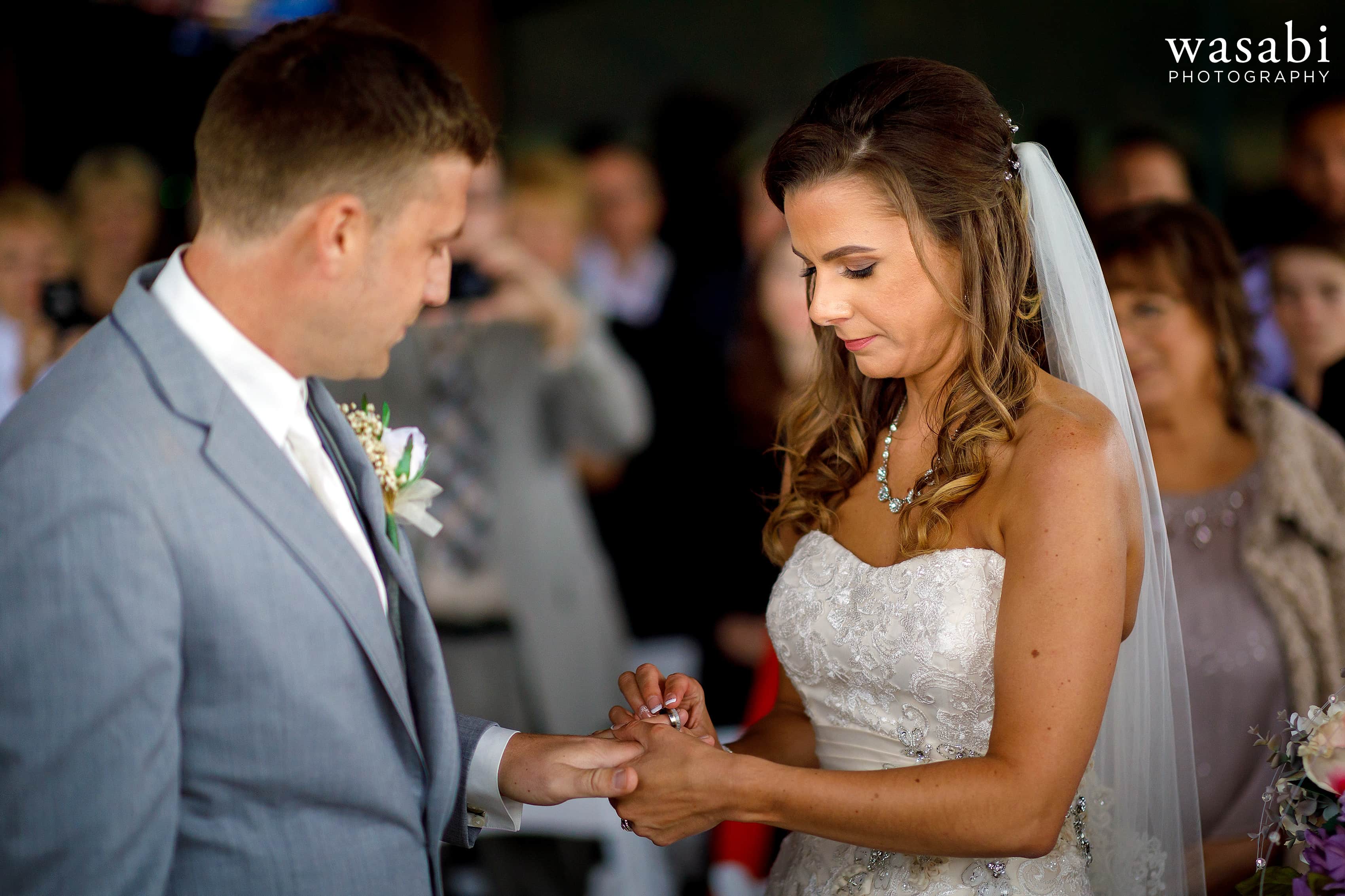 Bride and groom exchange rings during Buck's Run Golf Club wedding ceremony in Mount Pleasant, Michigan.
