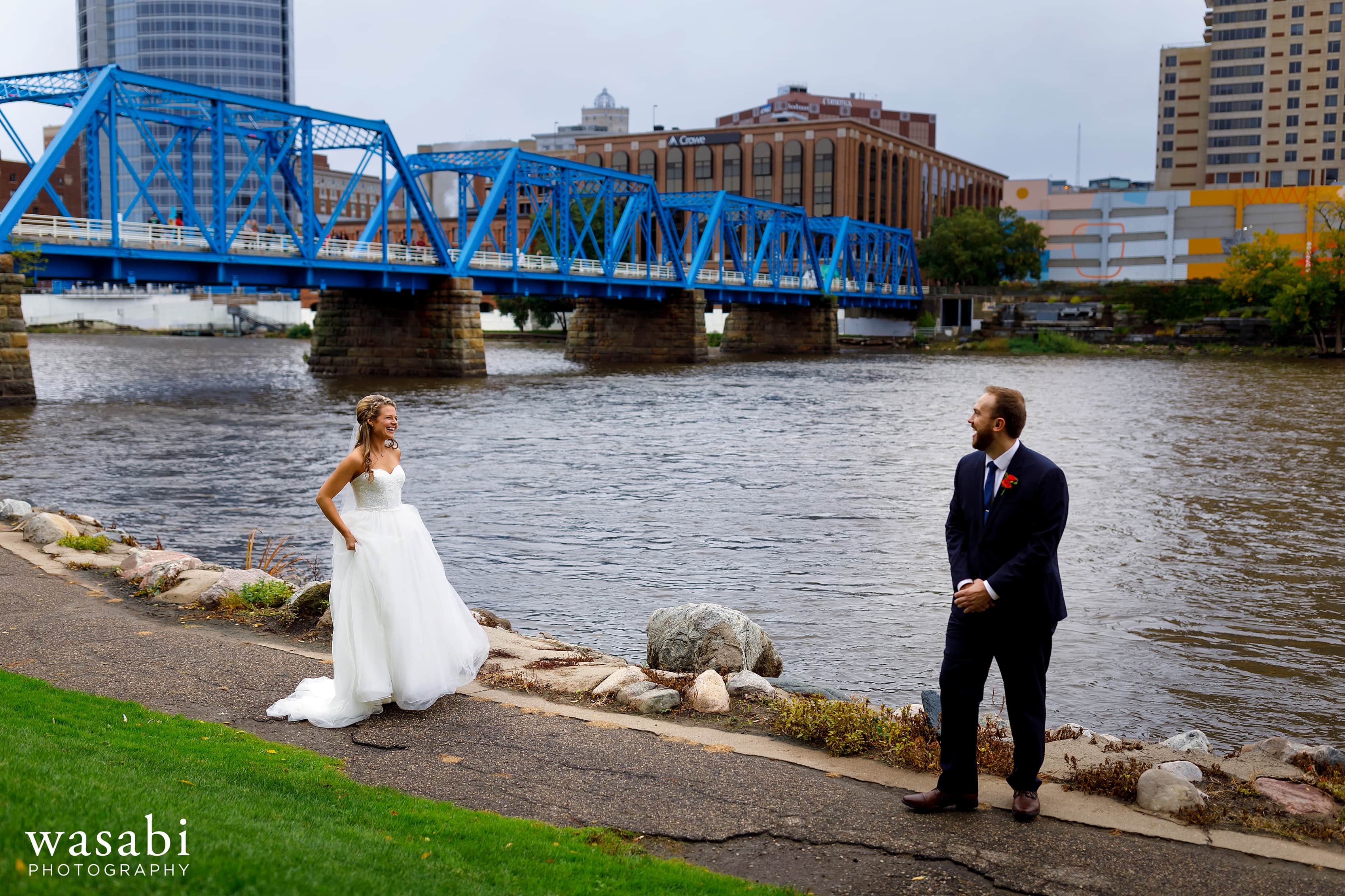 bride and groom first look on river by Blue Bridge in Grand Rapids