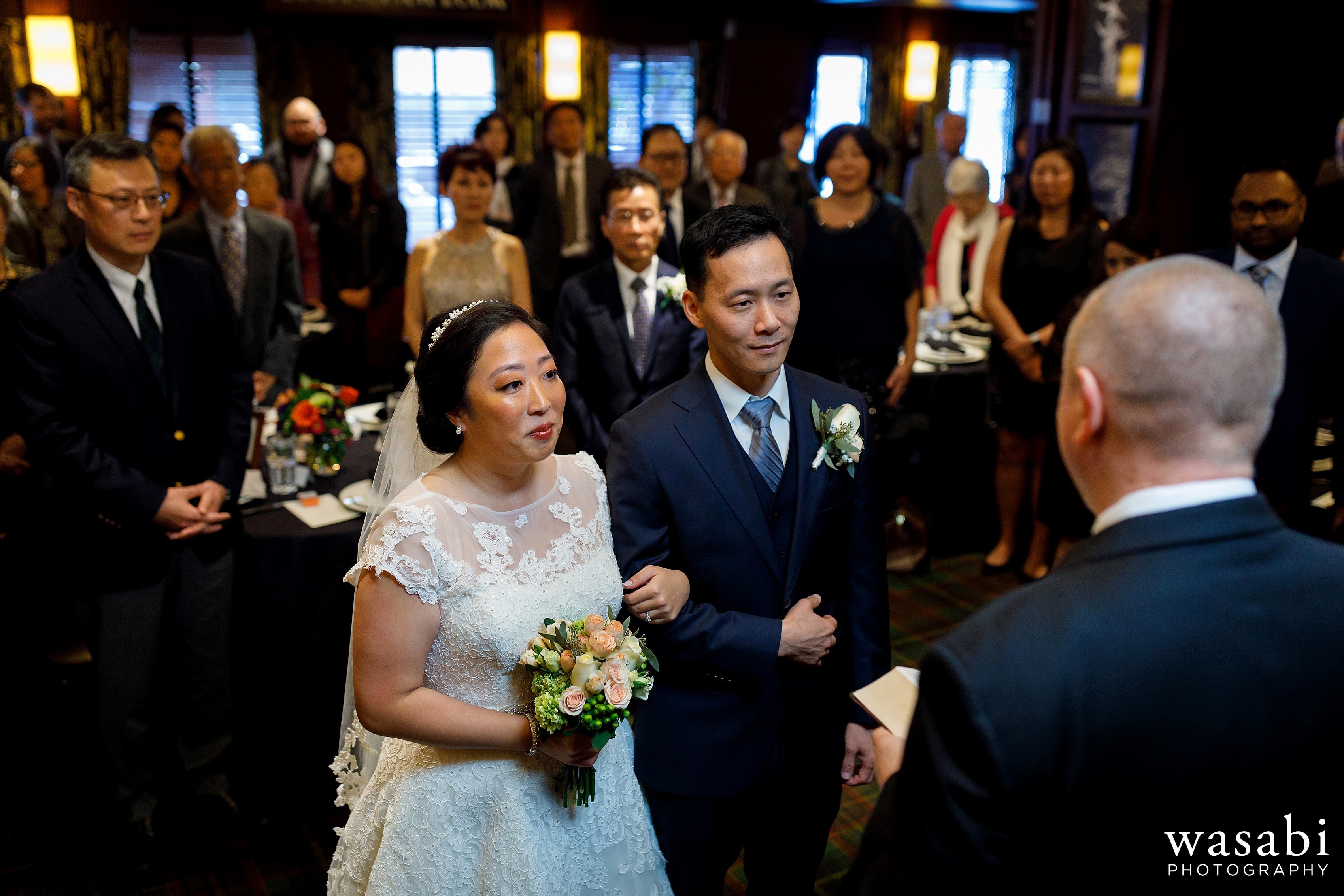 bride and groom listen to officiant during Wildfire Restaurant wedding ceremony in Chicago
