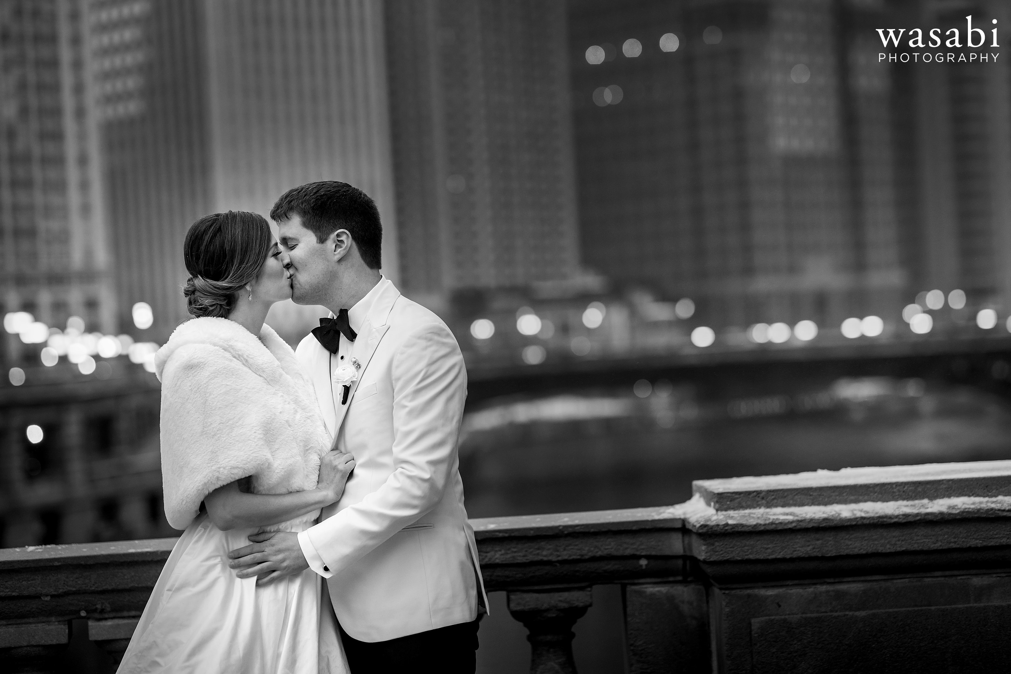 Bride and groom kiss on Michigan Ave. Bridge with Chicago River and skyline in background