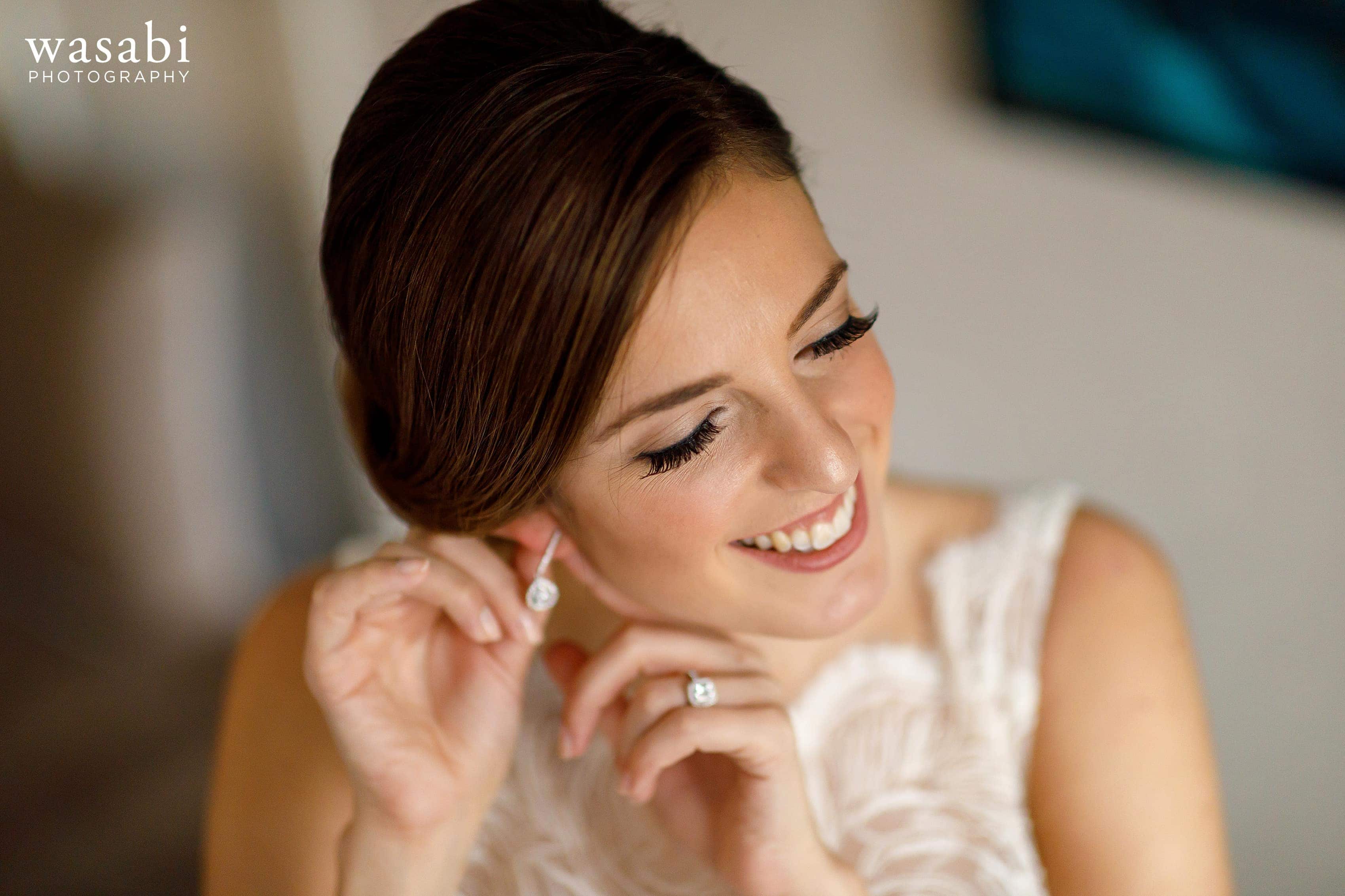 bride puts on earrings in the presidential suite while getting ready for wedding at InterContinental Chicago Magnificent Mile Hotel