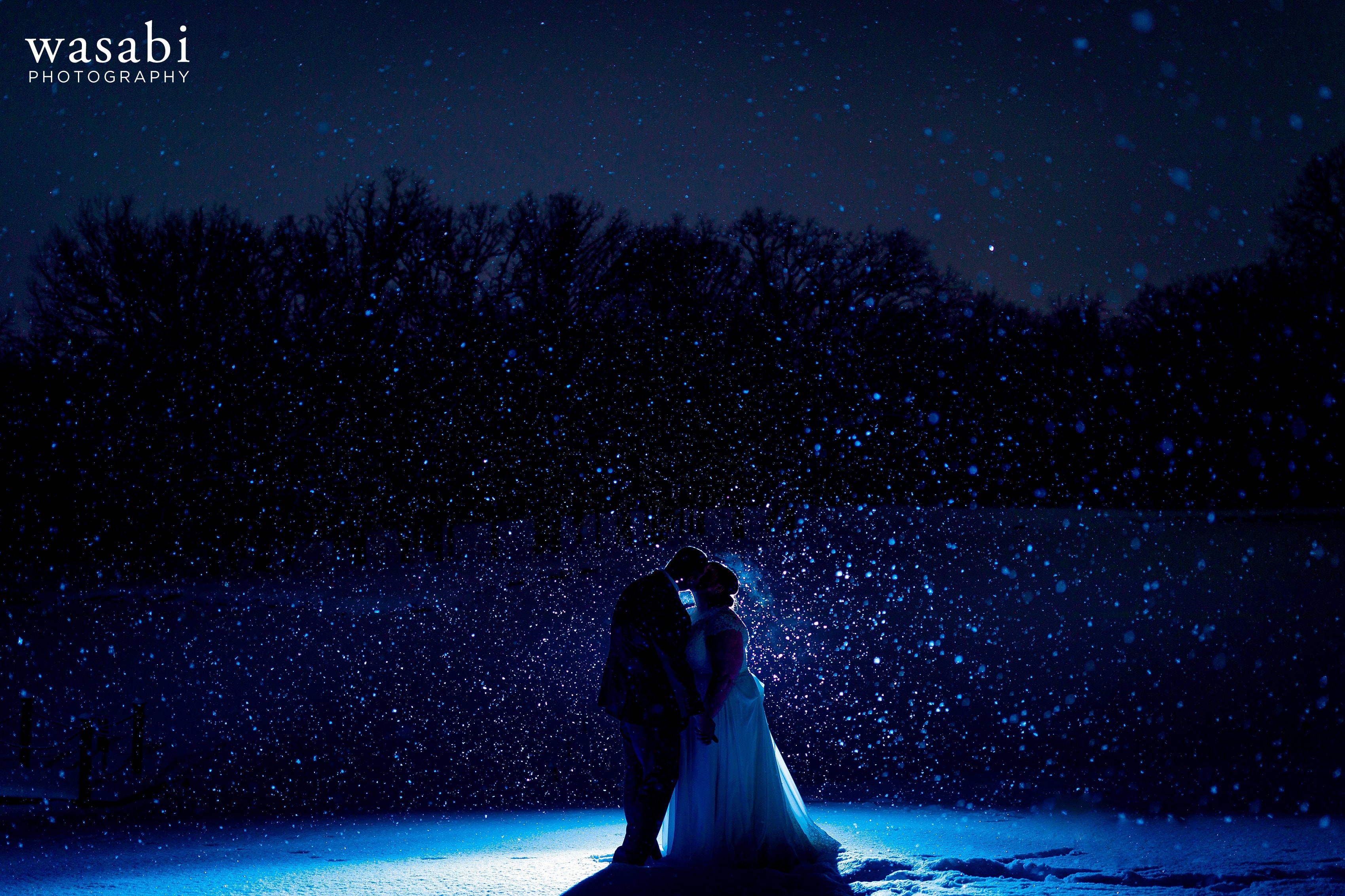 backlit photo with blue light snow coming down winter portrait silhouette of bride and groom at Oak Brook Bath and Tennis Club