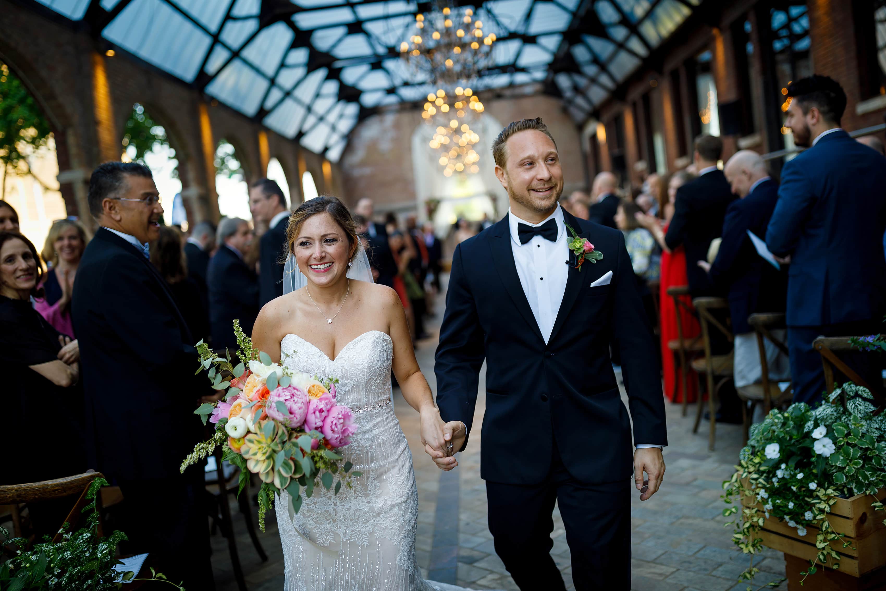 bride and groom walk back down the aisle after wedding ceremony at Bridgeport Art Center Sculpture Garden in Chicago