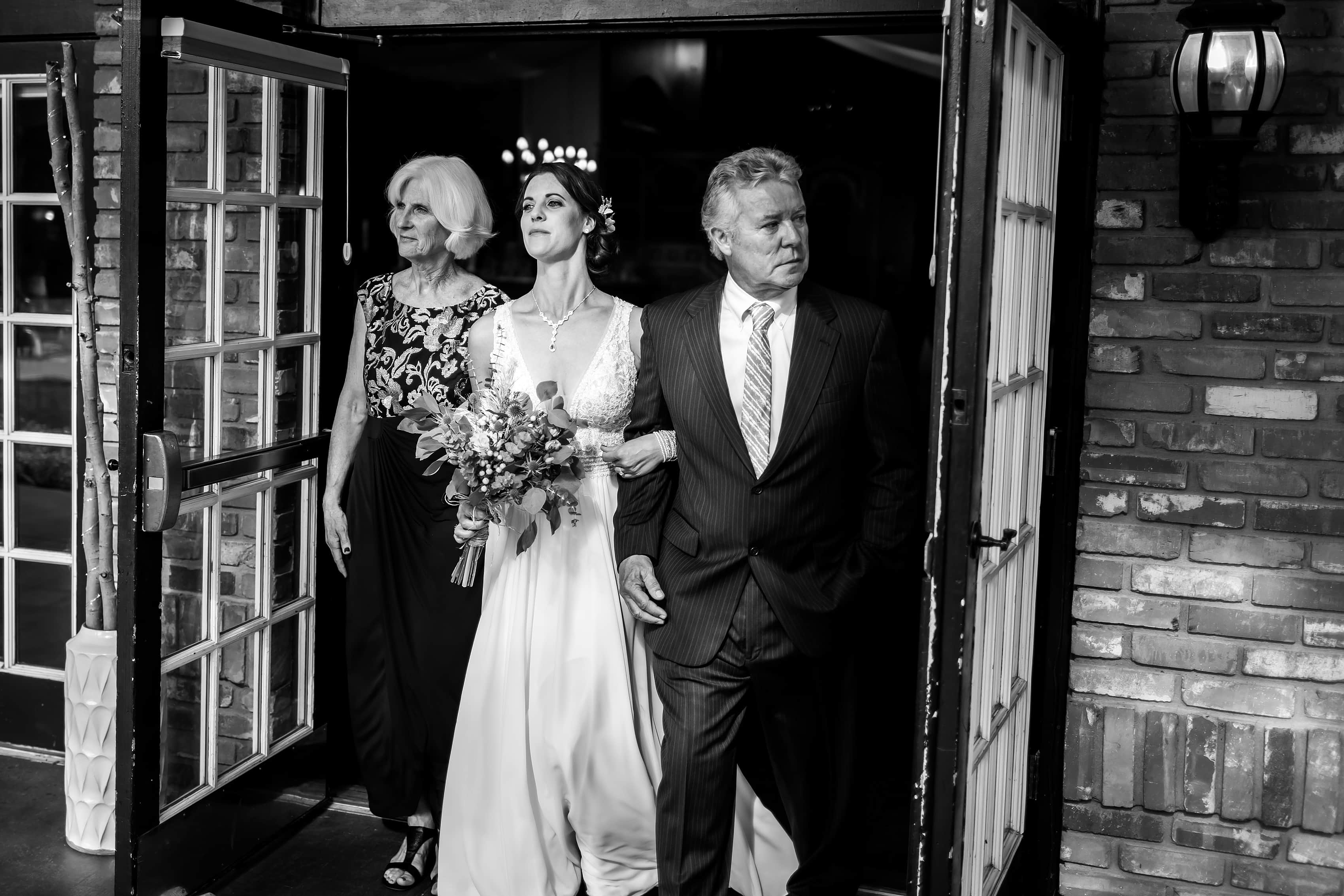 bride walks out with her parents during wedding ceremony at Lionsgate Event Center wedding