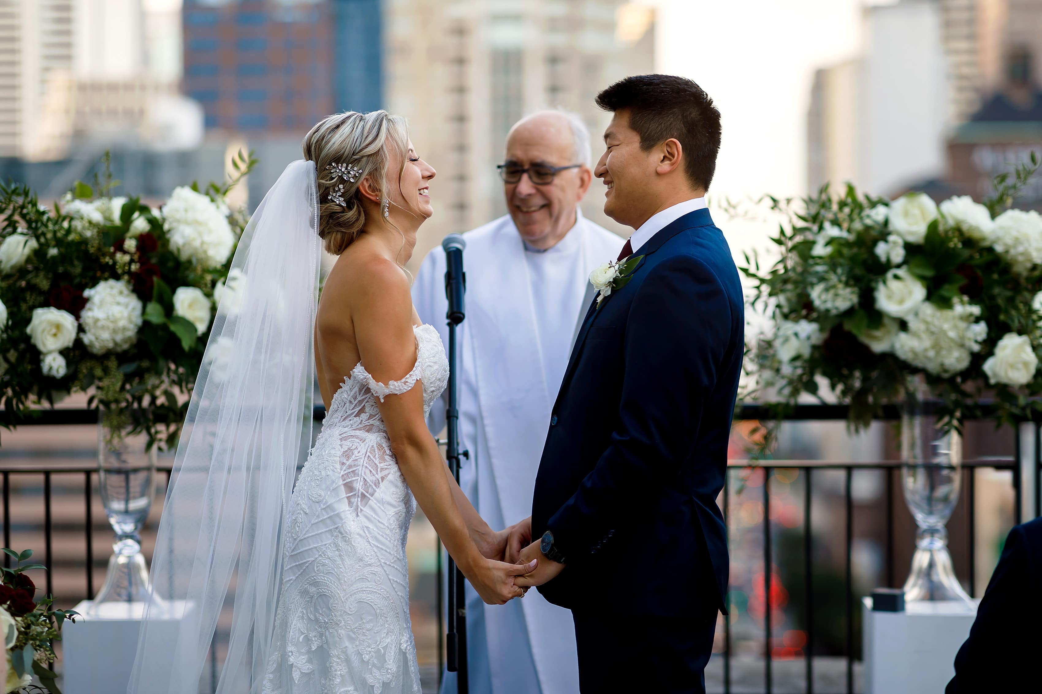 bride and groom share a laugh during wedding ceremony on the patio of the Lux Suite at The Gwen Hotel in downtown Chicago