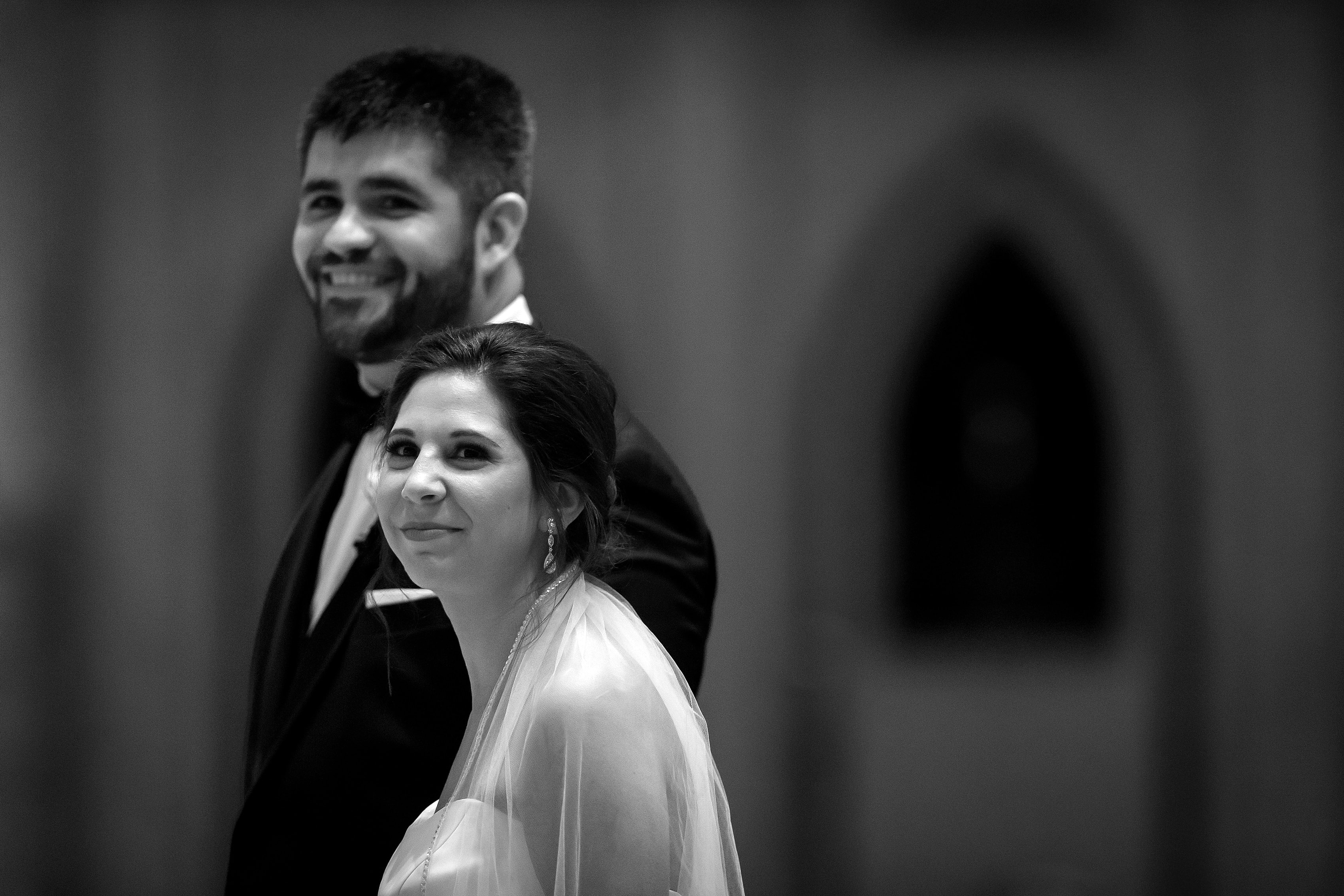 bride and groom smile at the front of the church during their wedding at Holy Name Cathedral in downtown Chicago