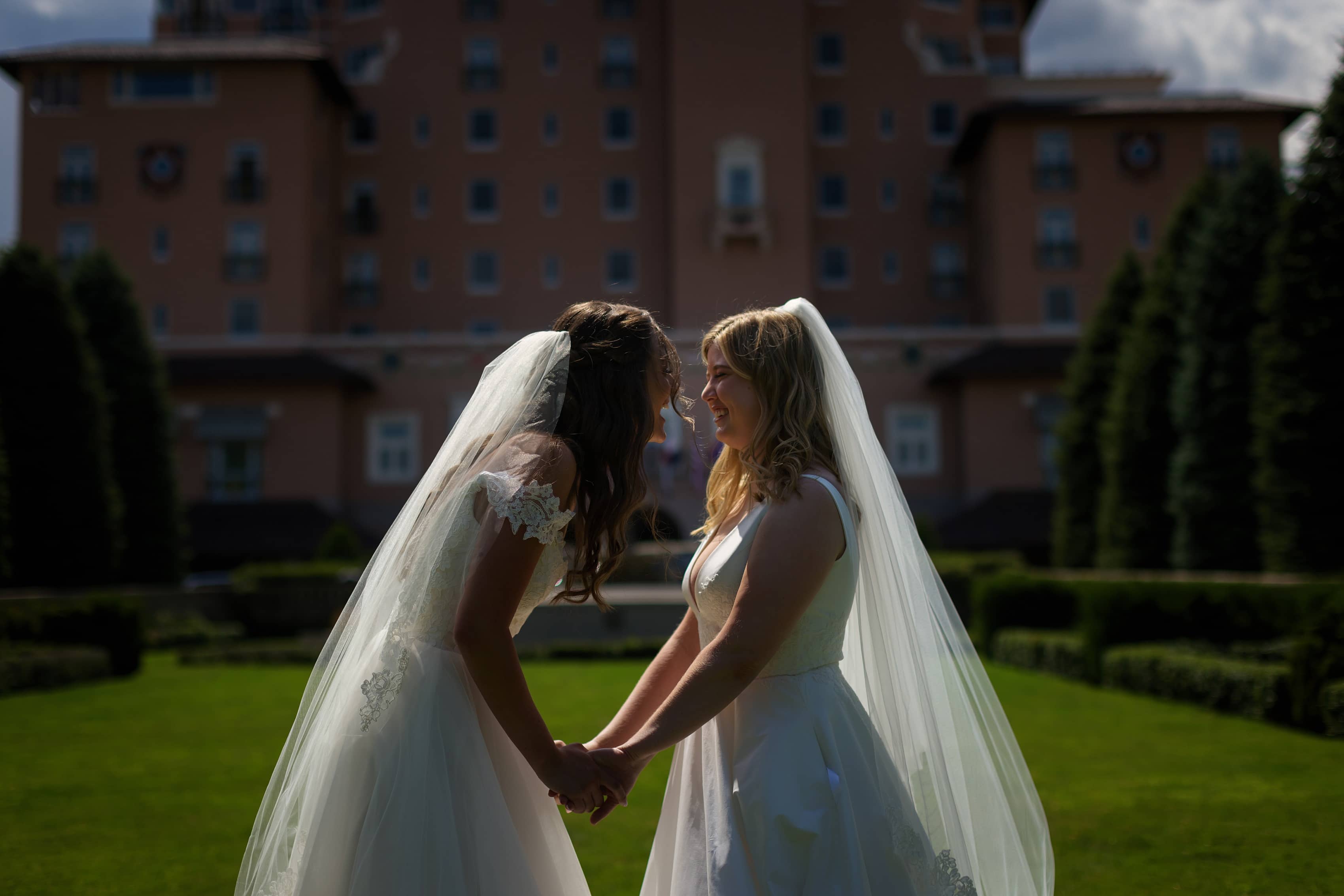 two brides see each other during first look on the front lawn at The Broadmoor in Colorado Springs, Colorado
