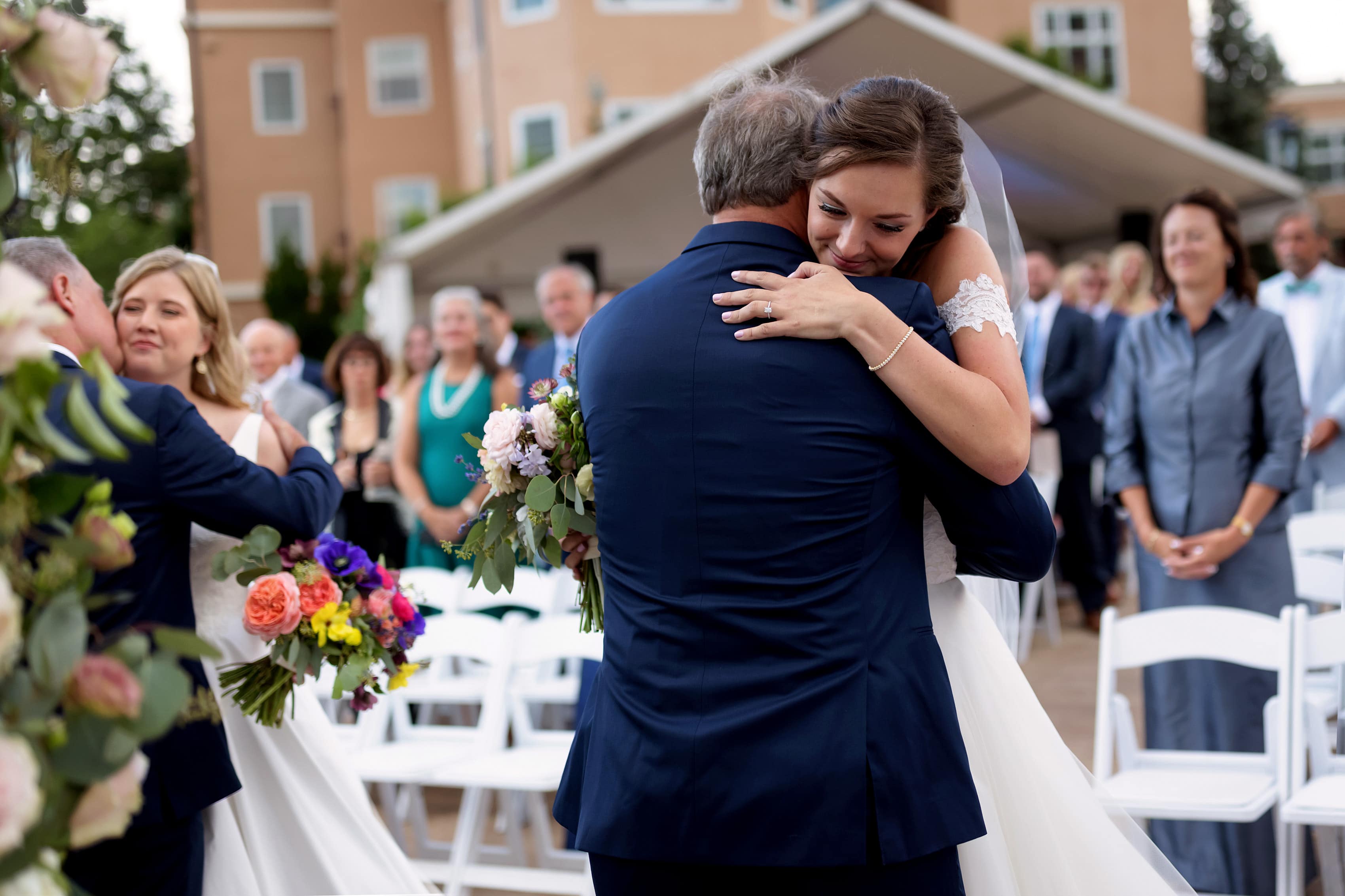 two brides hug their fathers during wedding at The Broadmoor in Colorado Springs, Colorado