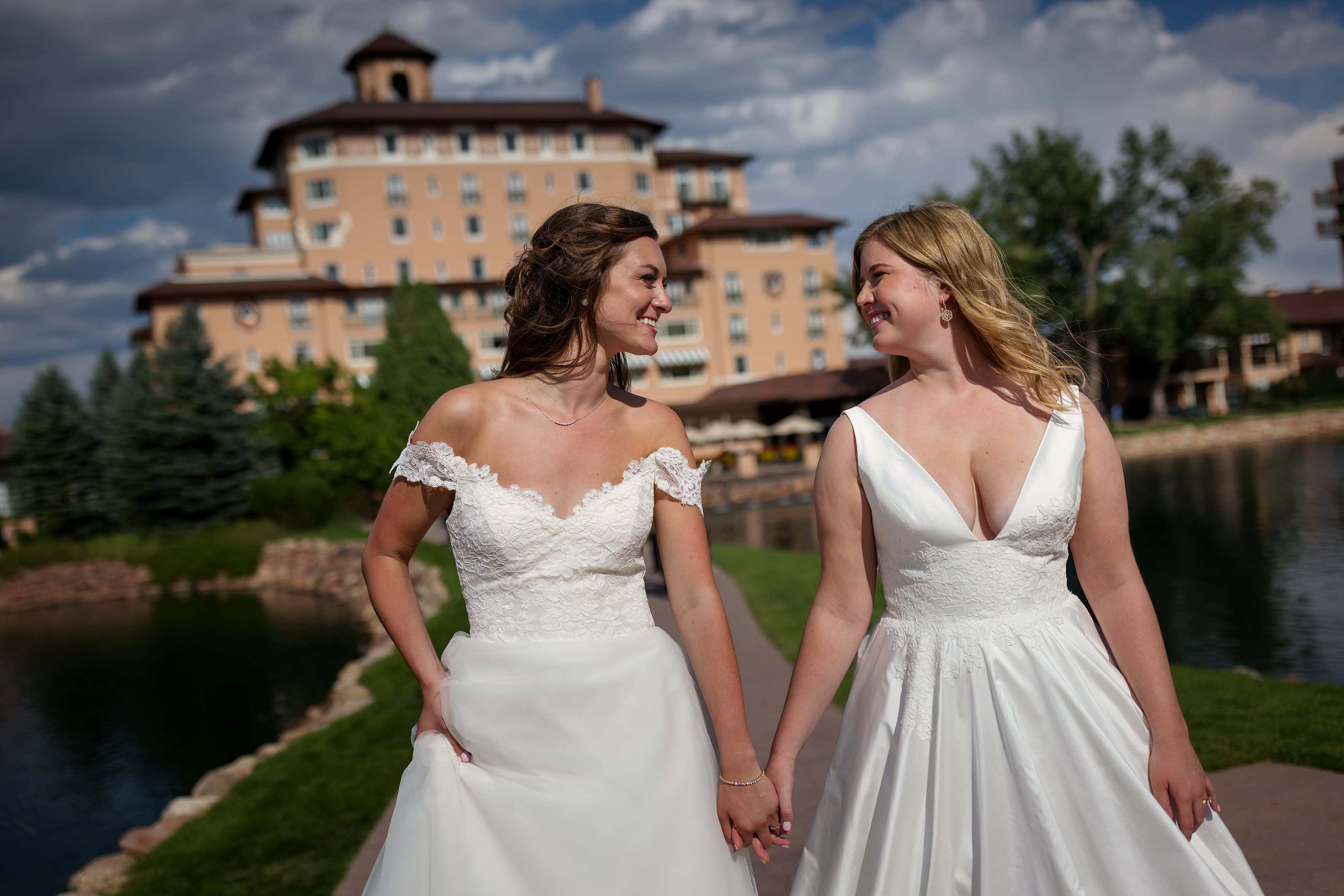 two brides walk together for wedding portraits at The Broadmoor in Colorado Springs, Colorado