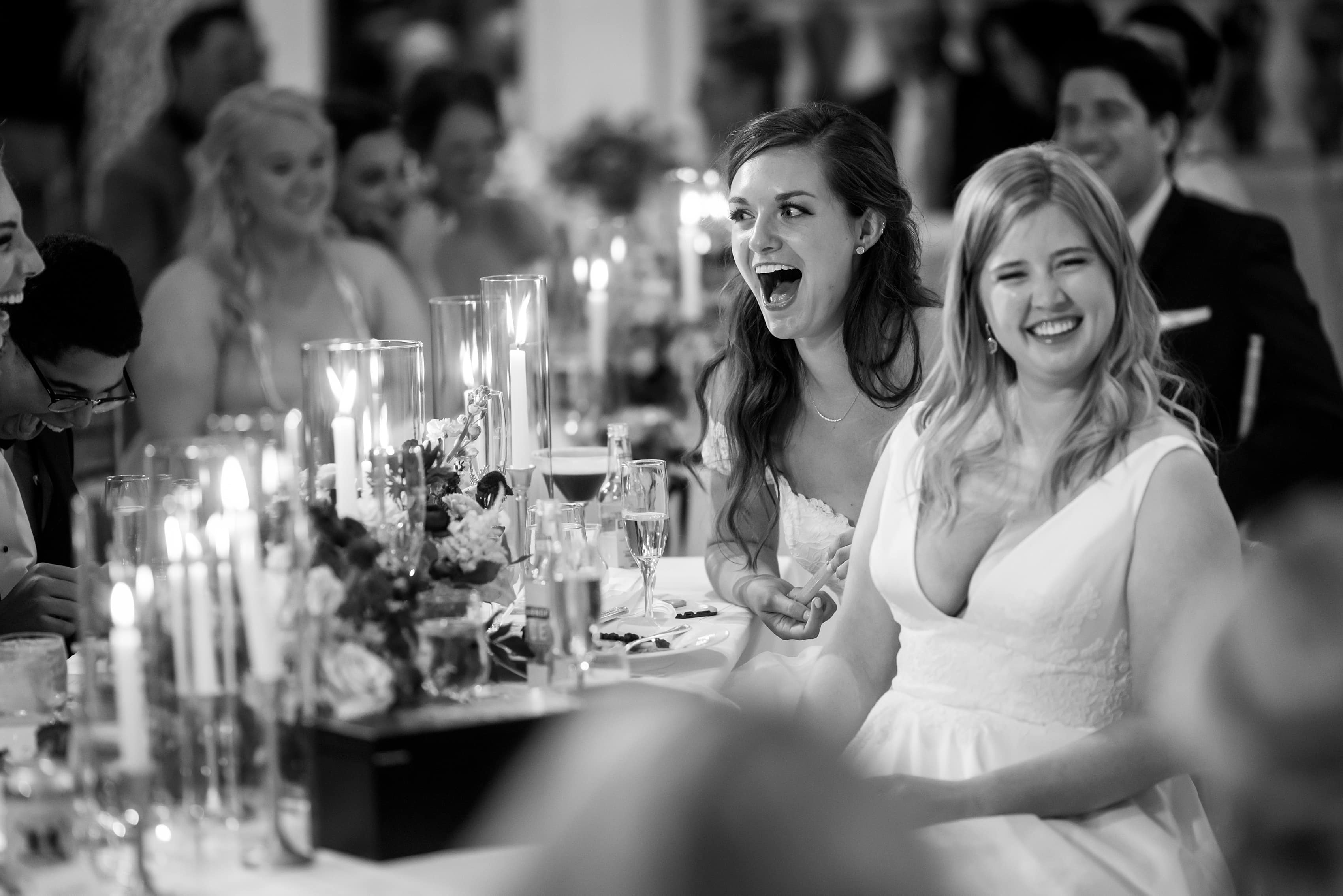 brides react during wedding reception toasts