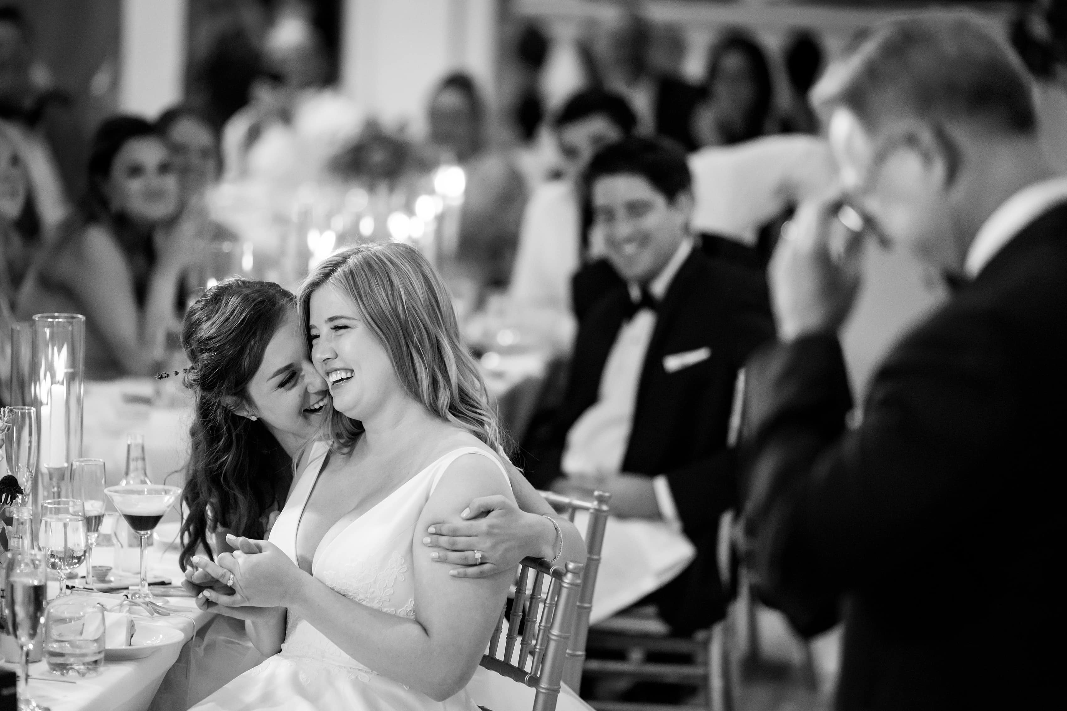 brides react during wedding reception toasts