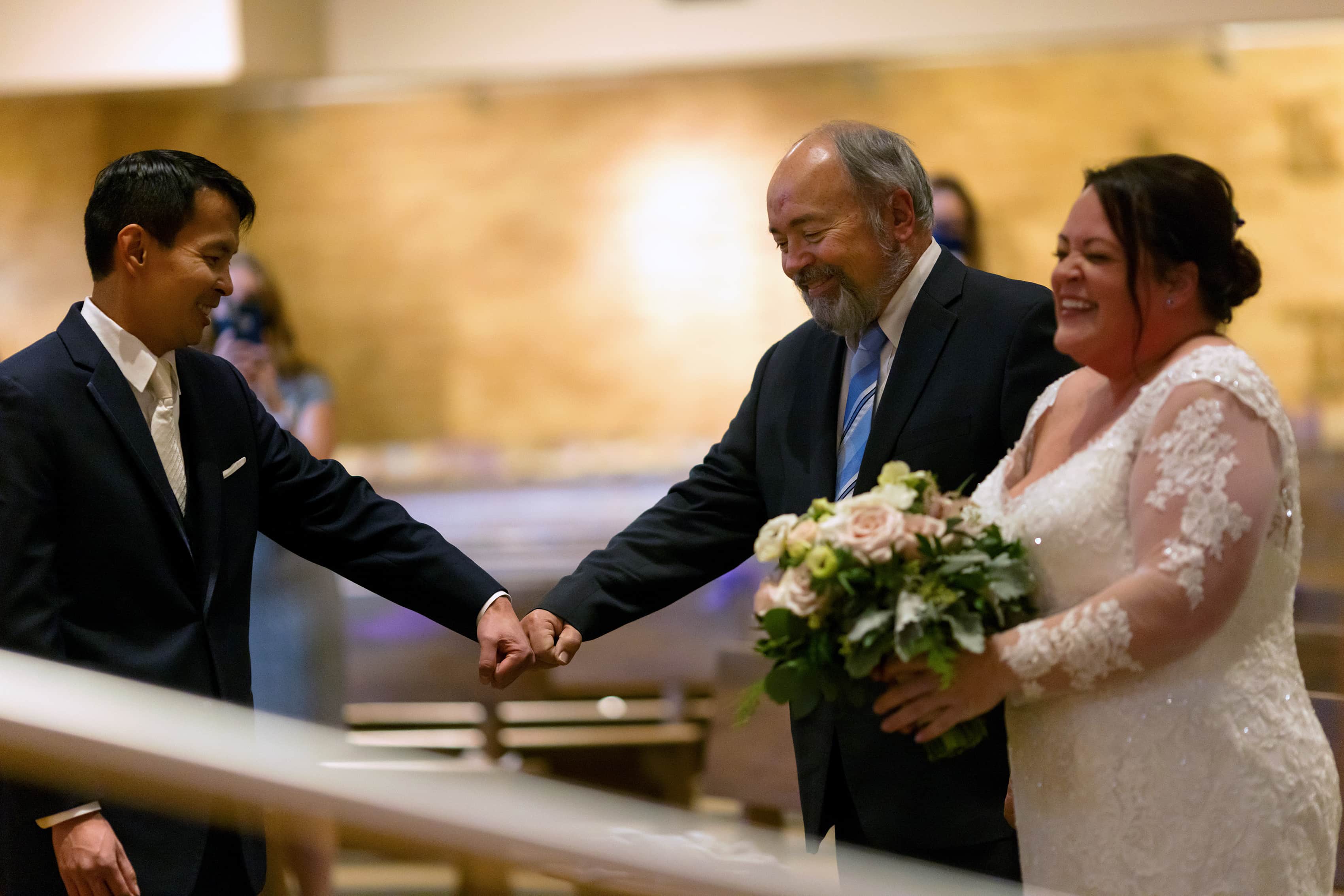 bride walks down the aisle with her father during wedding at st. scholastica parish