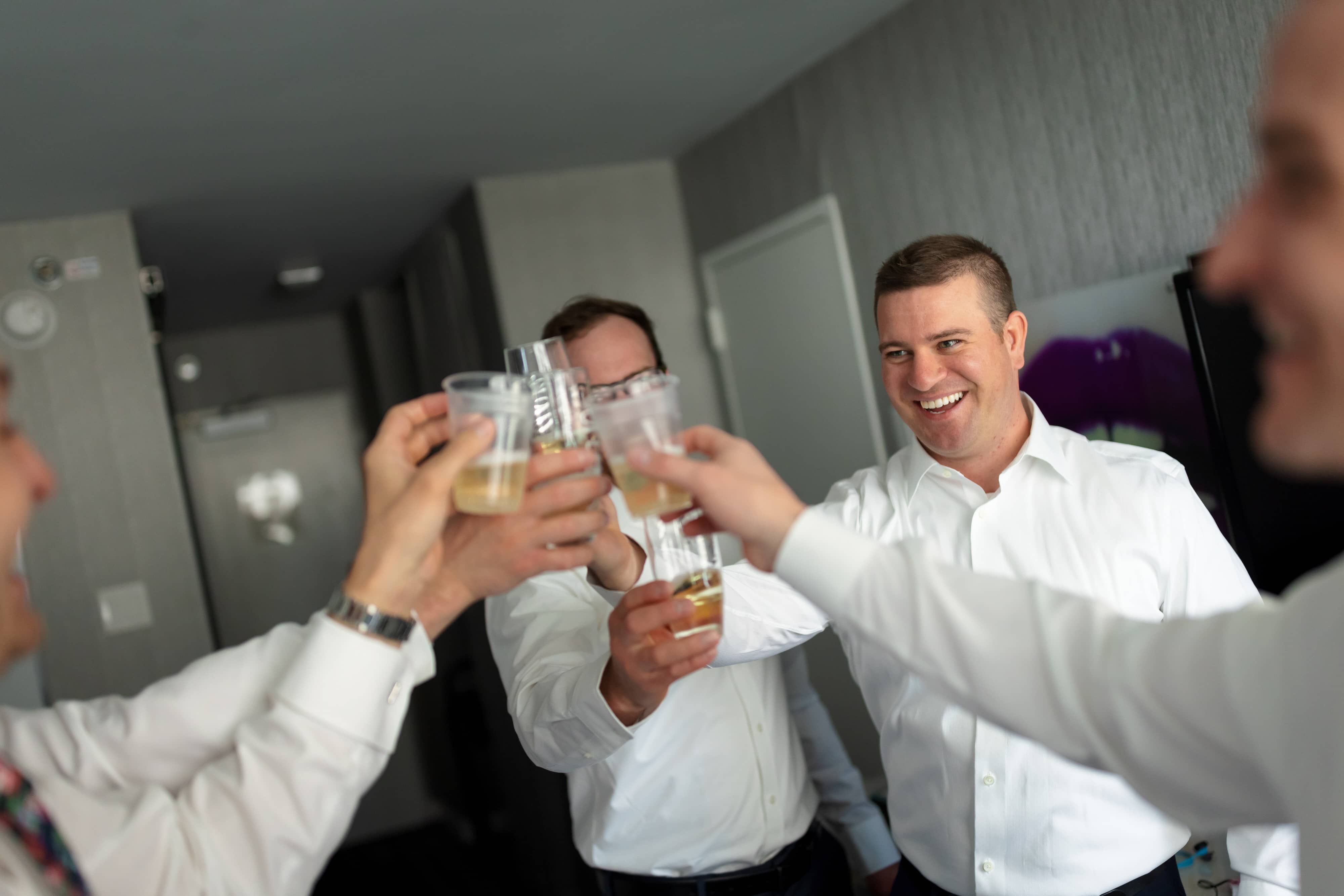 Groom and groomsmen make a toast before leaving for wedding ceremony