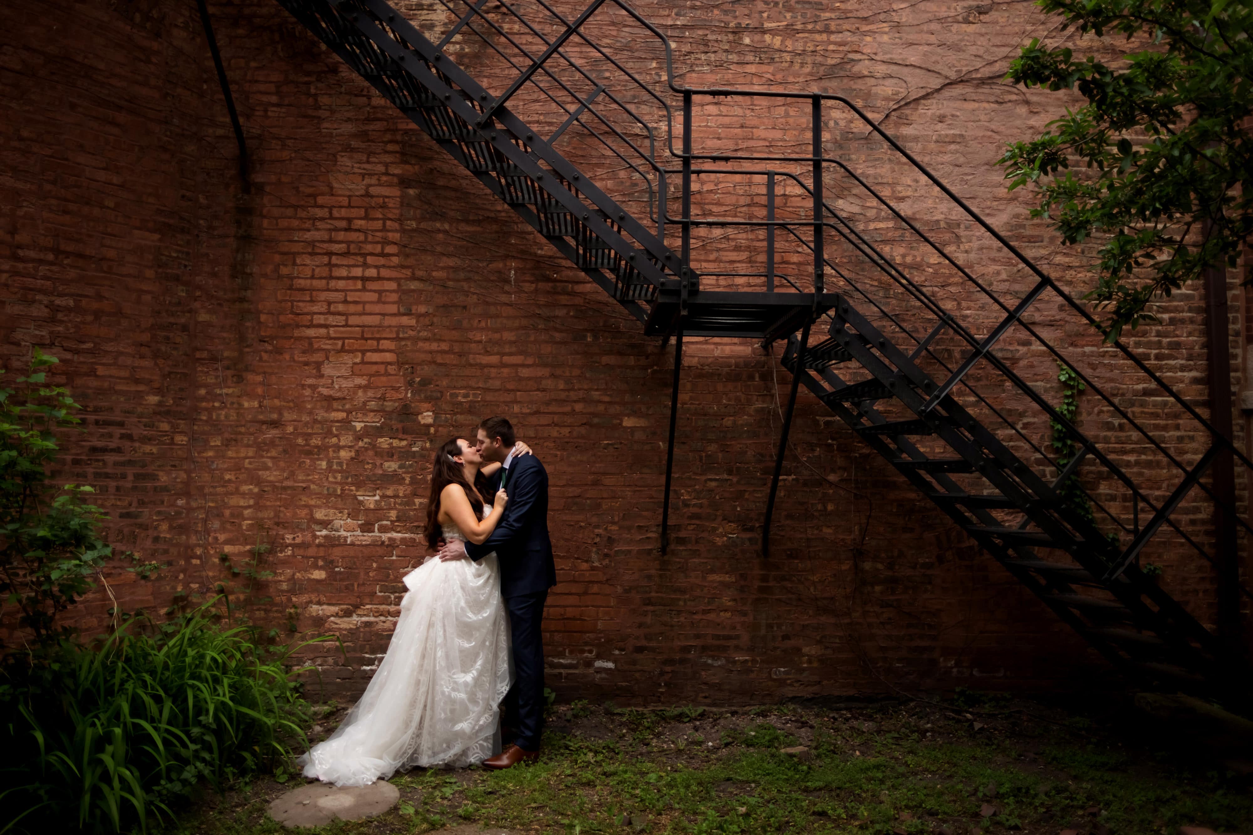 wedding portrait with bride and groom with brick and metal staircase