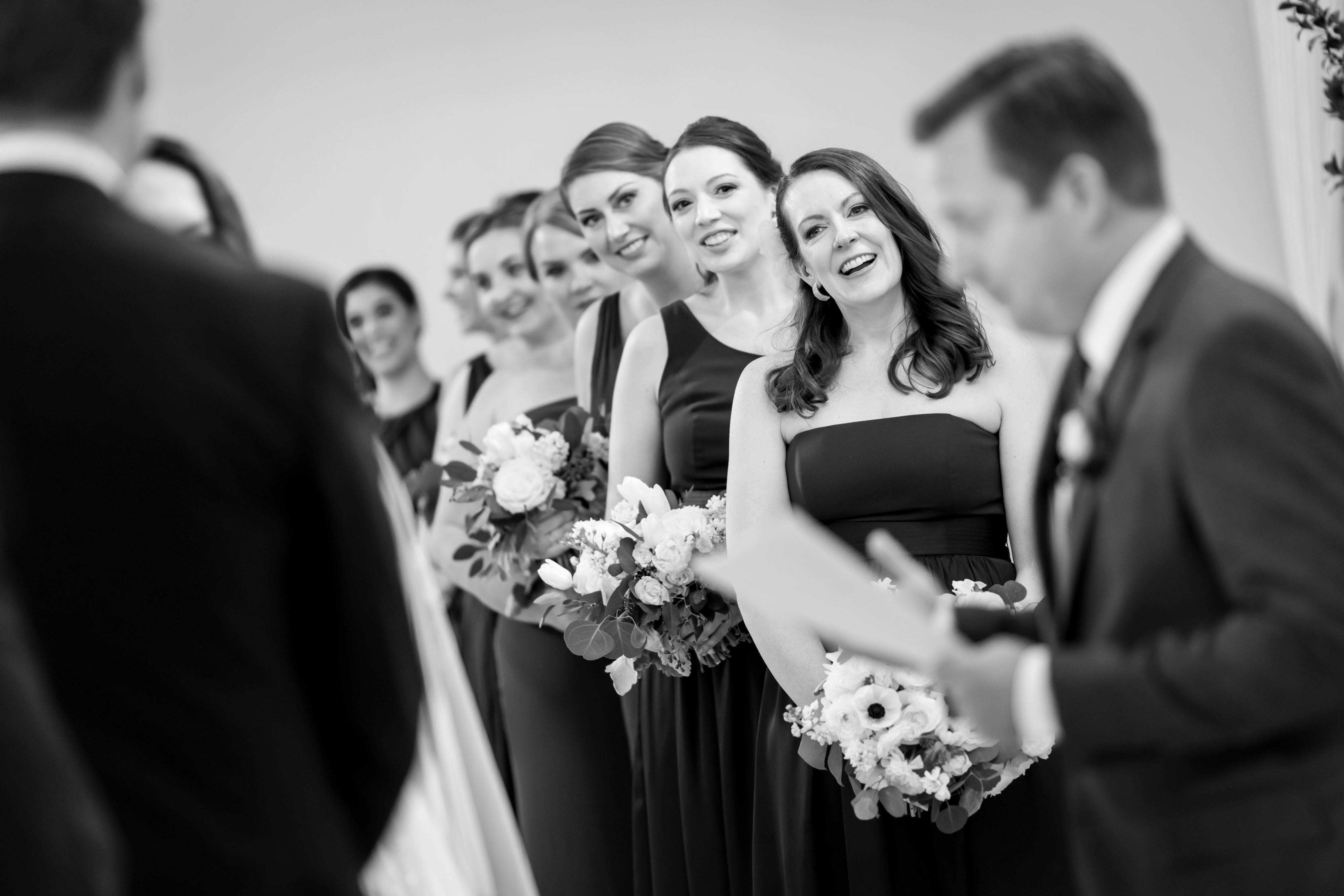 bride and bridesmaids laugh during wedding ceremony at Stan Mansion