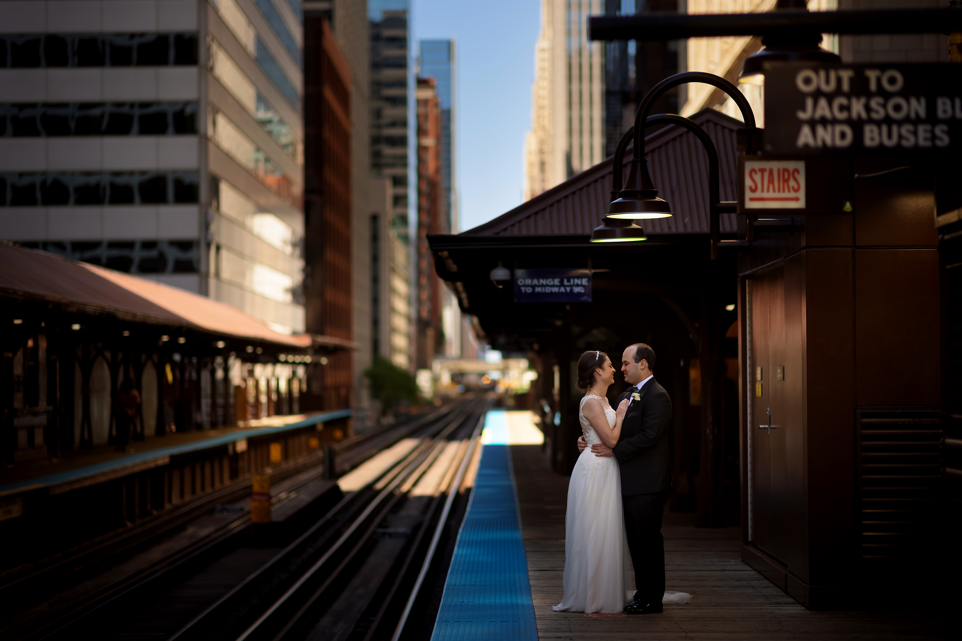 Bride and groom pose for wedding portraits at the Quincy Station El stop in Chicago