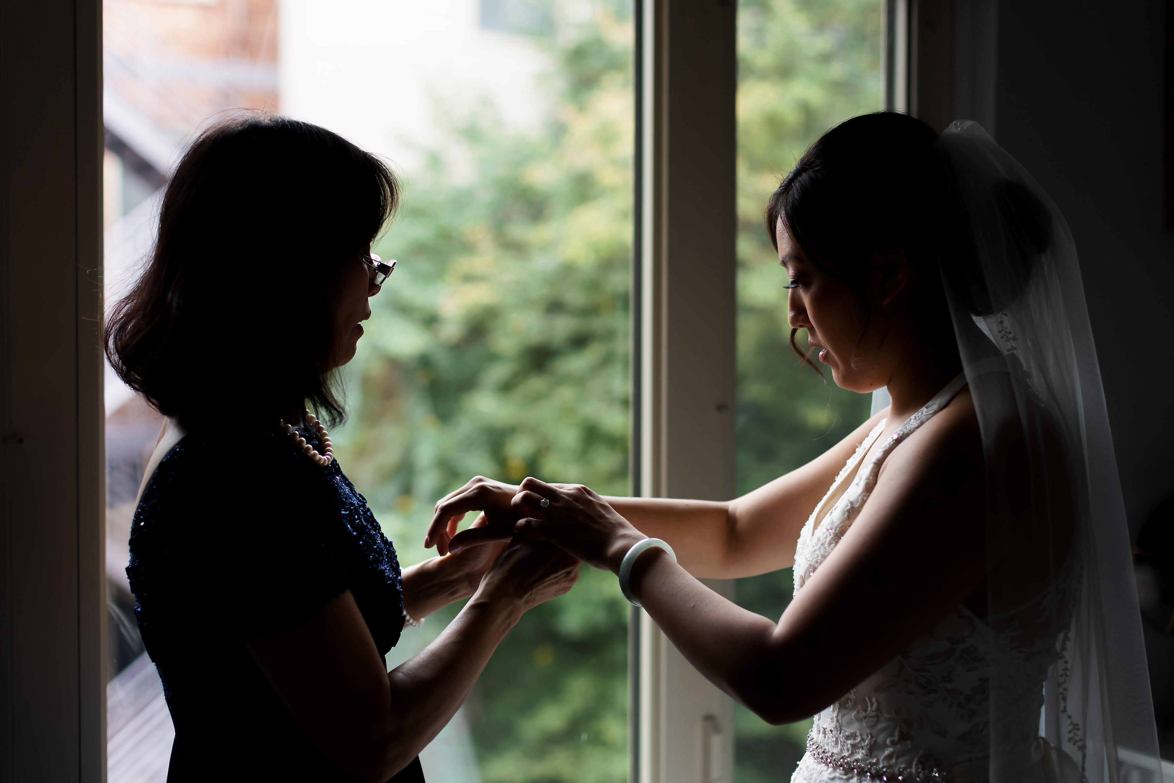 bride and mom silhouette putting on jewelry