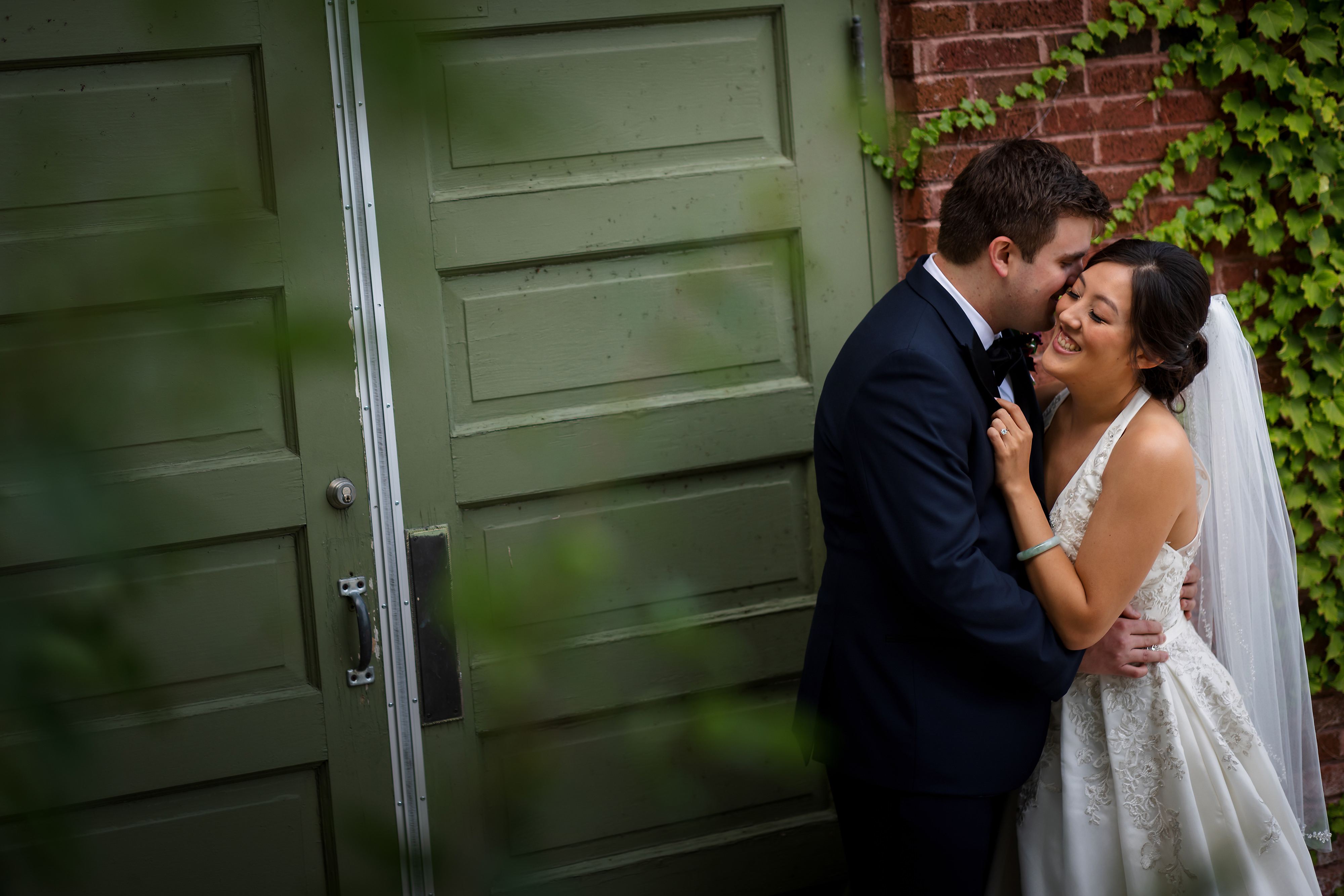 bride and groom pose for portrait in front of ivy in Lincoln Park