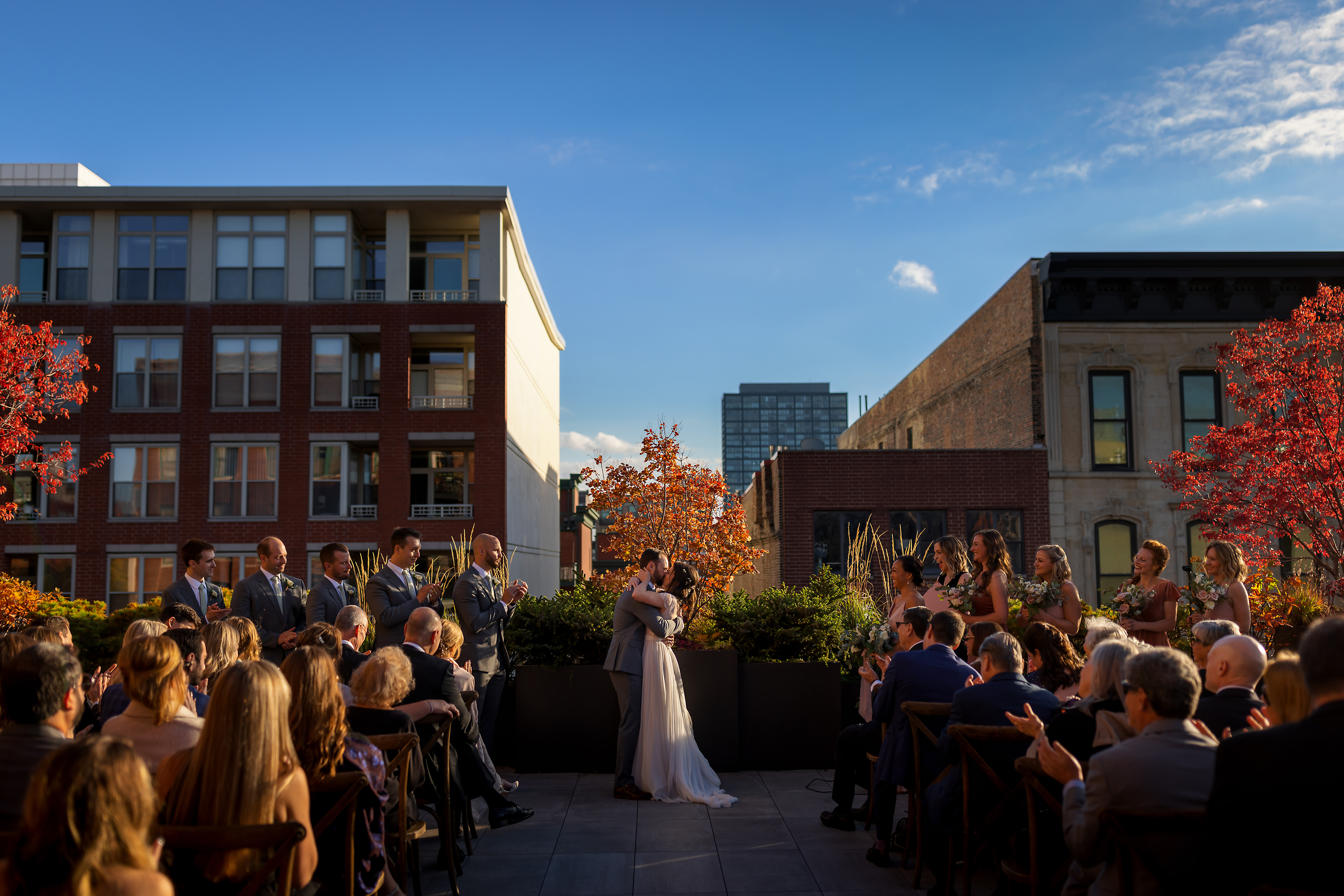 Bride and groom kiss at the end of rooftop wedding ceremony at Loft Lucia in Chicago's West Loop neighborhood.