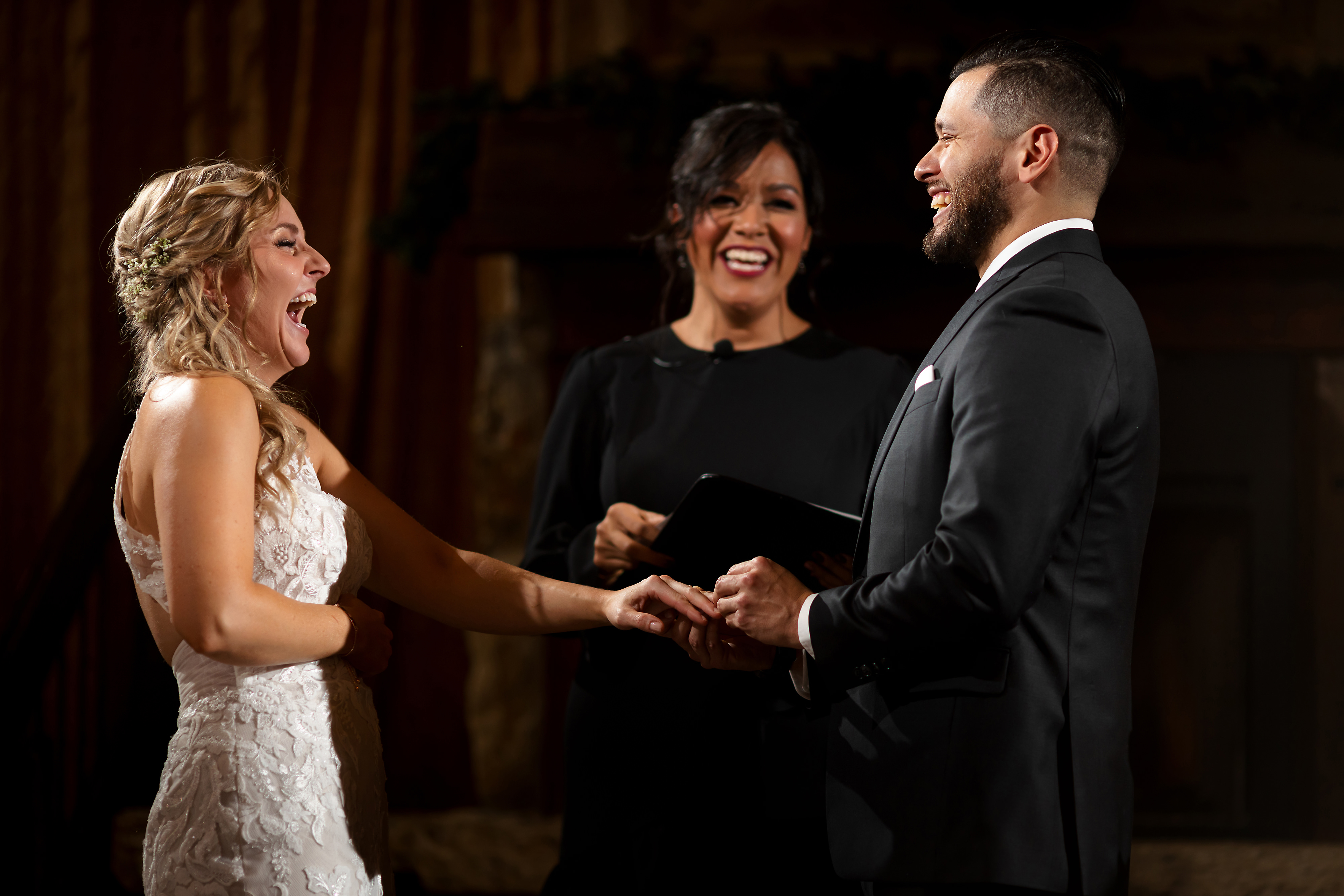 Bride and groom laugh during ring exchange of wedding ceremony at Two Brother Brewery in Aurora, Illinois