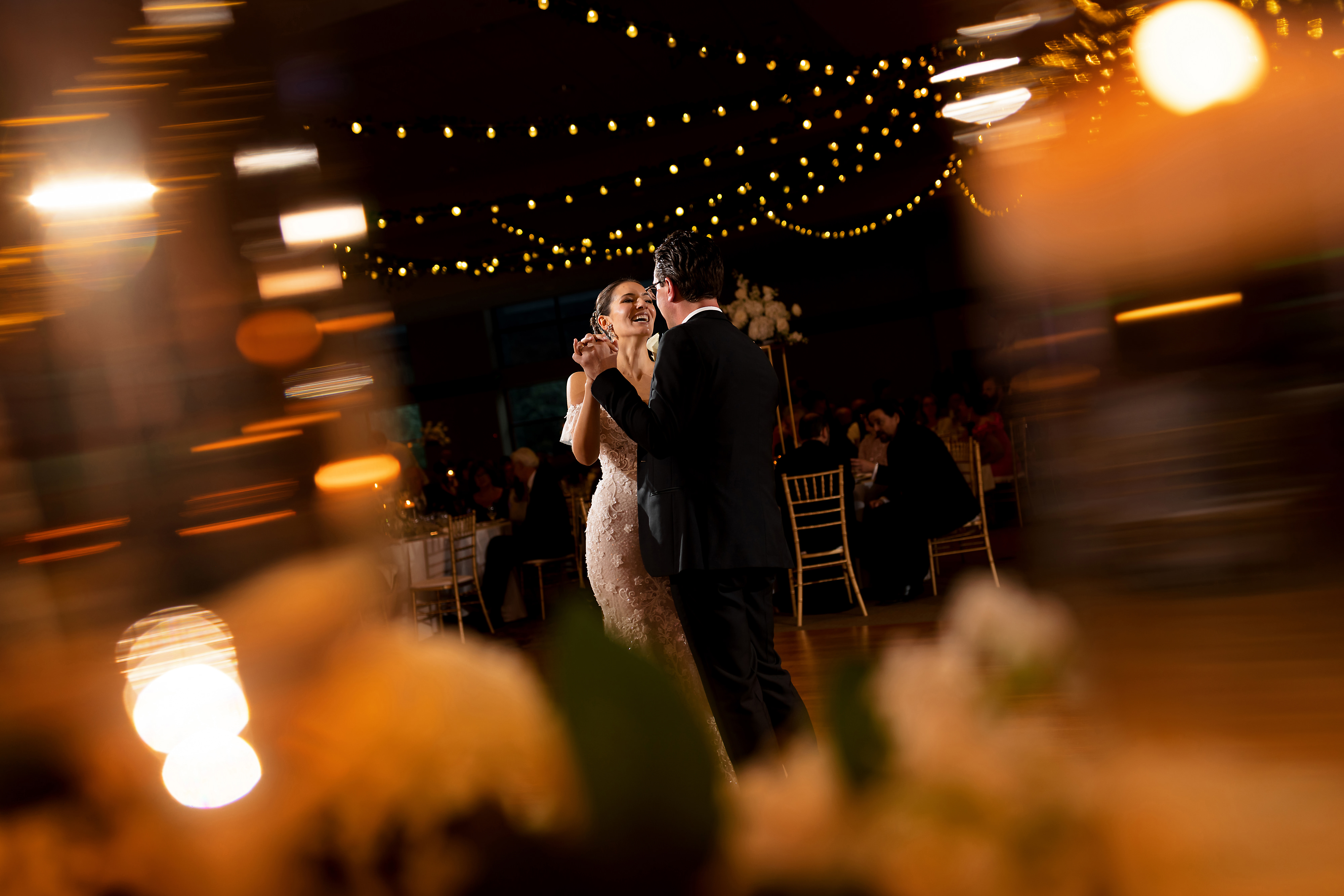 Bride and groom first dance with market lights during wedding reception at Halls of St. George in Schererville, Indiana