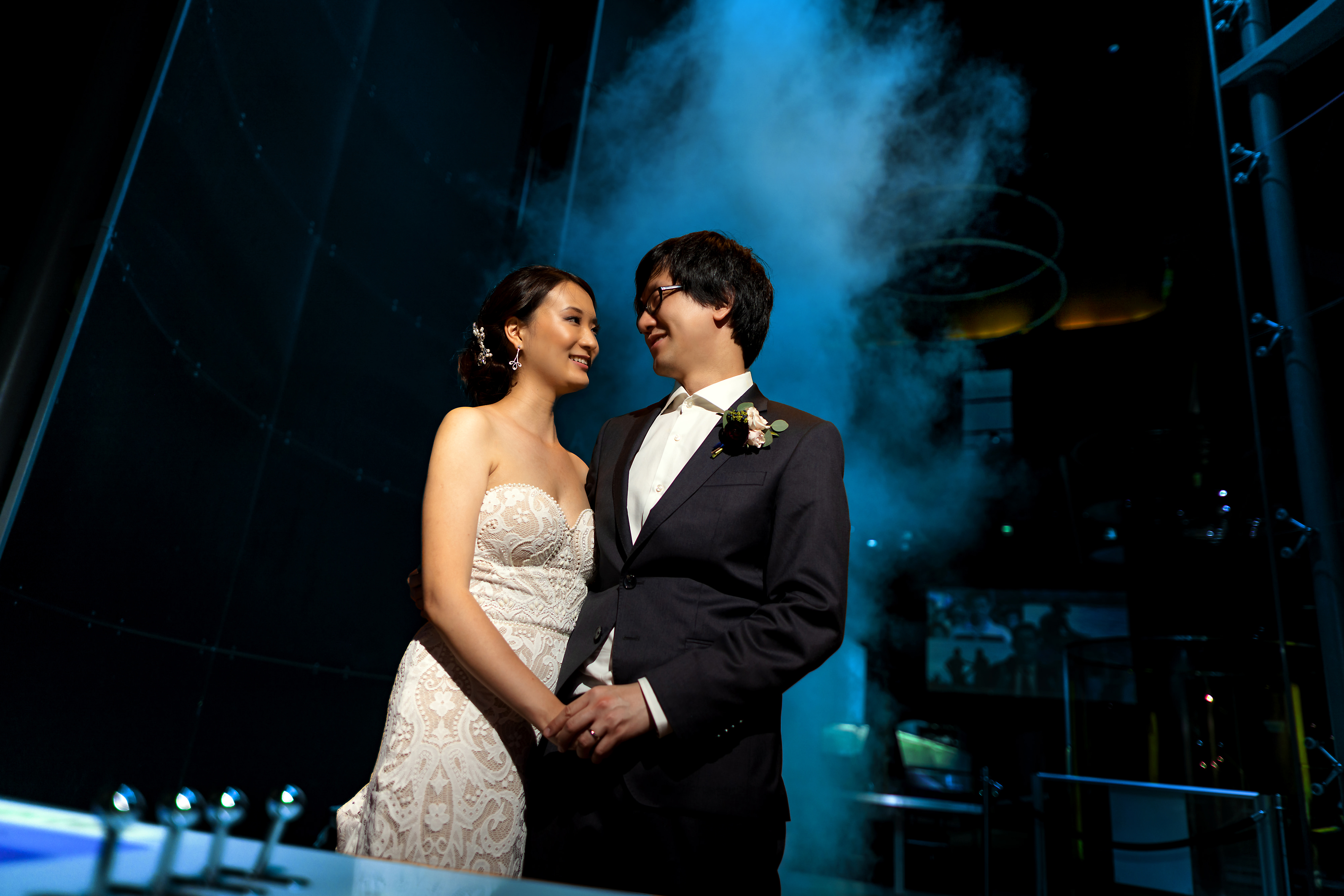 Bride and groom pose for portrait in front of the Tornado vortex exhibit during wedding reception at the Museum of Science and Industry in Chicago
