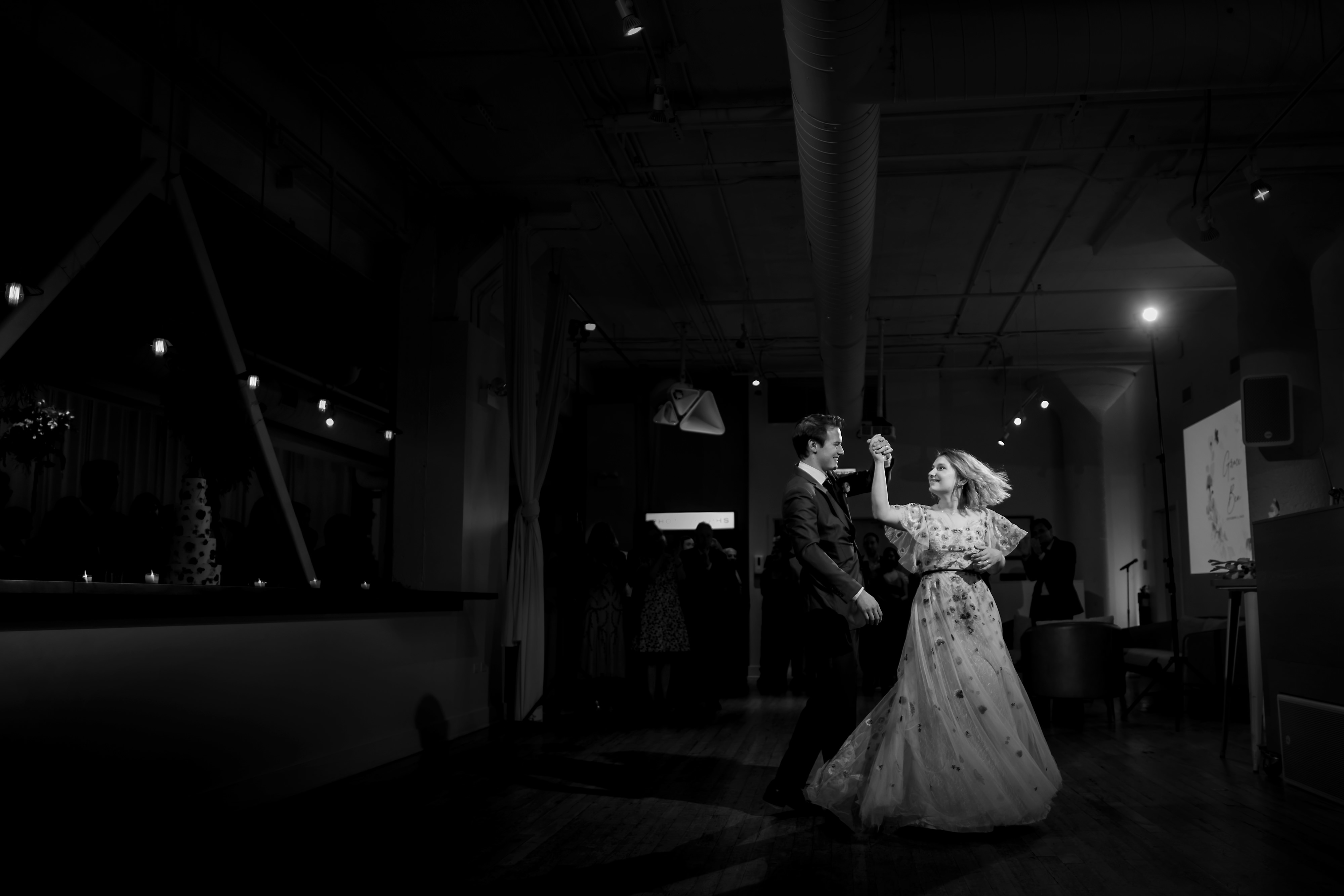 black and white wide angle first dance spin of couple during wedding reception at Greenhouse Loft in Chicago