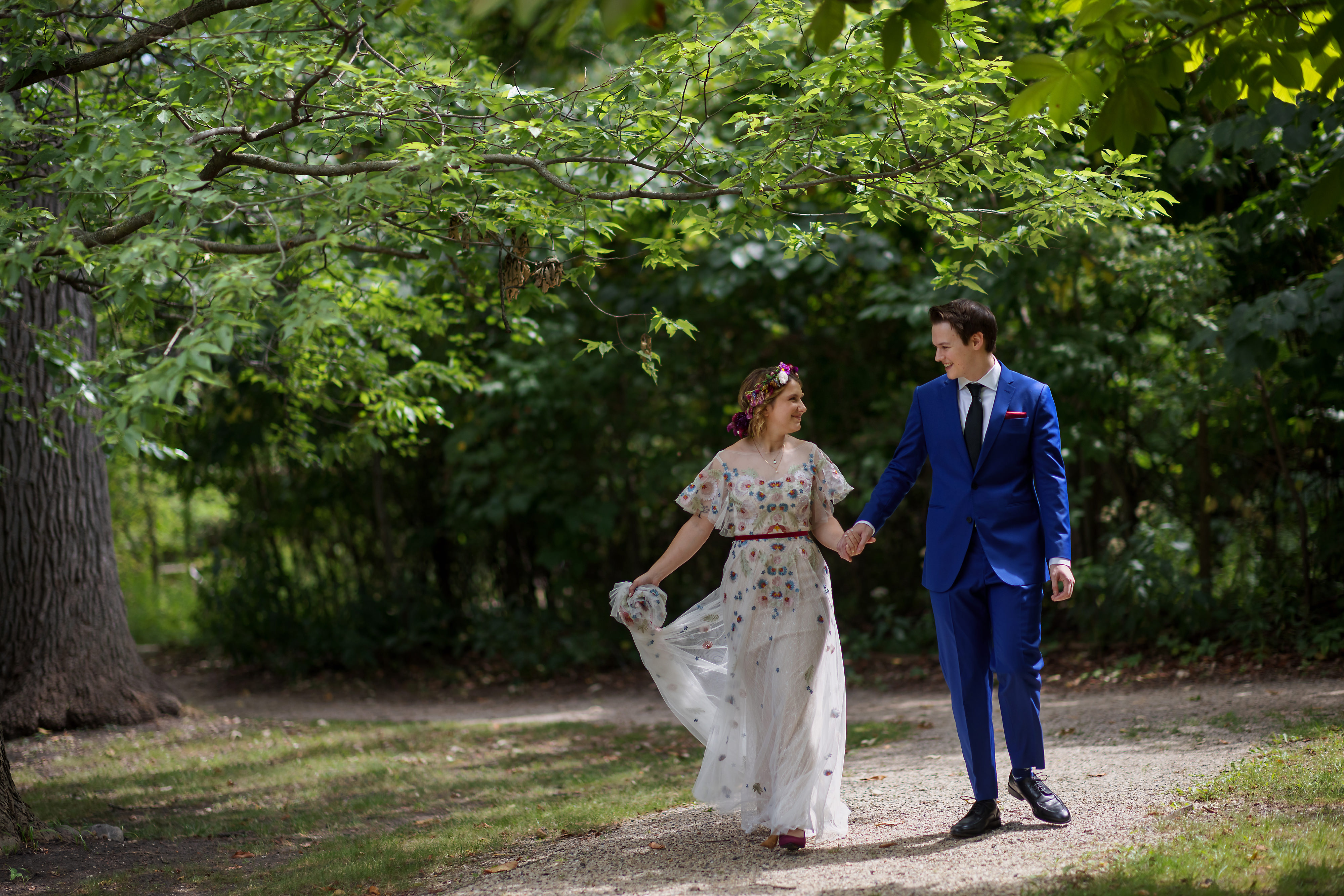 bride and groom walk along trail before wedding ceremony at The Grove Redfield Estate in Glenview
