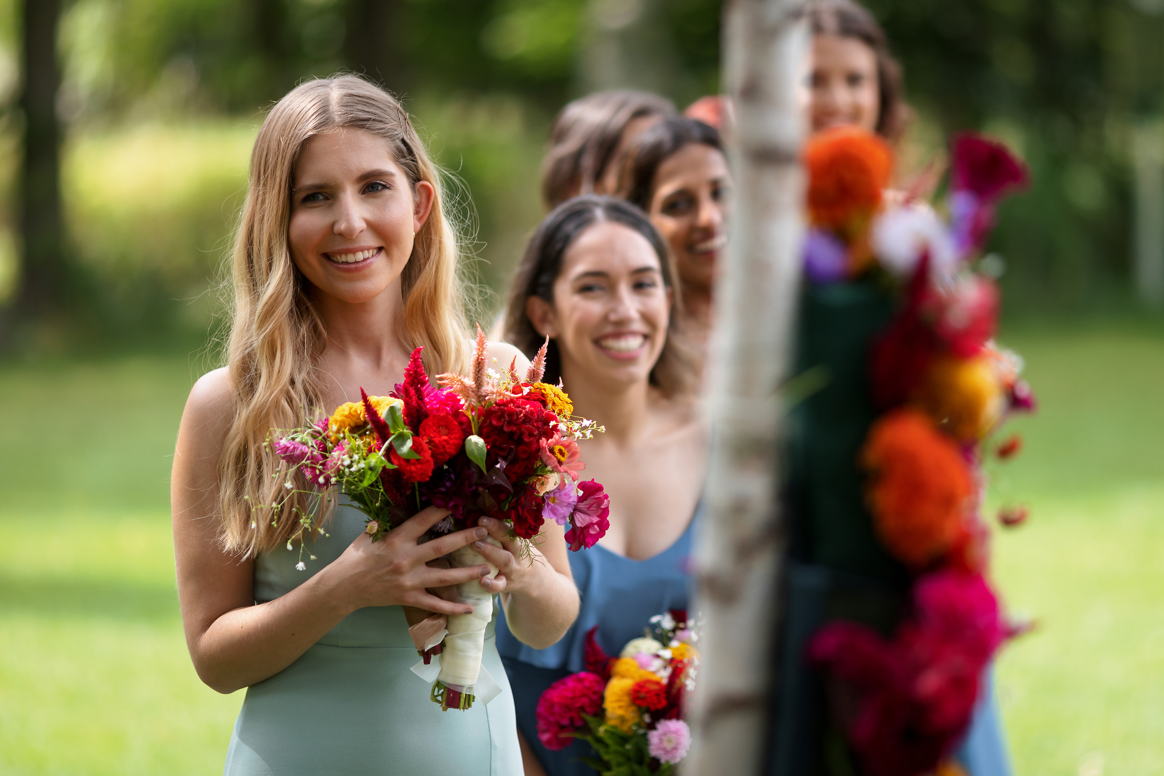 bridesmaids laugh during outdoor wedding ceremony at The Grove Redfield Estate in Glenview with the house in the background